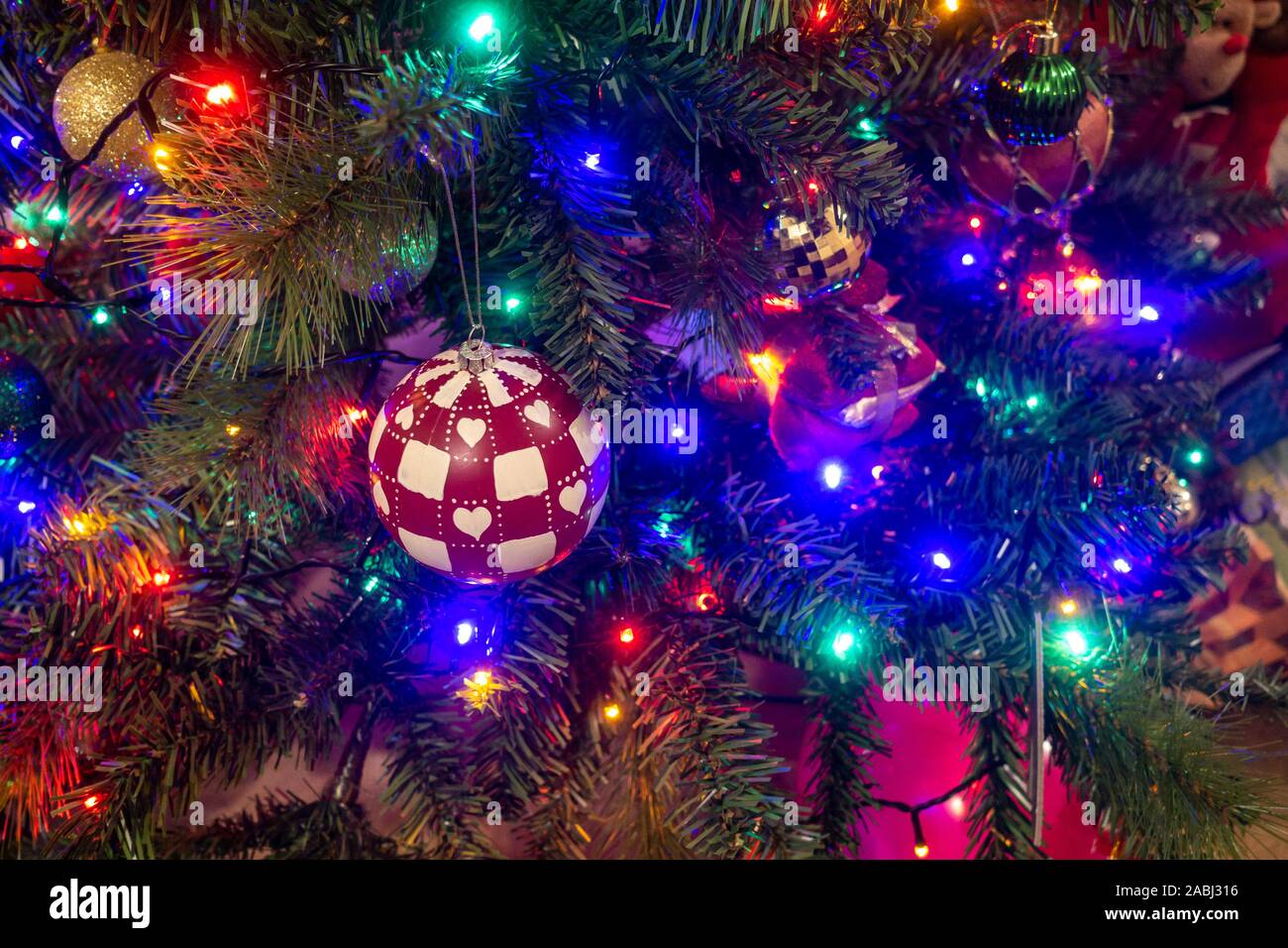 Colourful fairy lights and baubles decorate a Christmas tree Stock ...