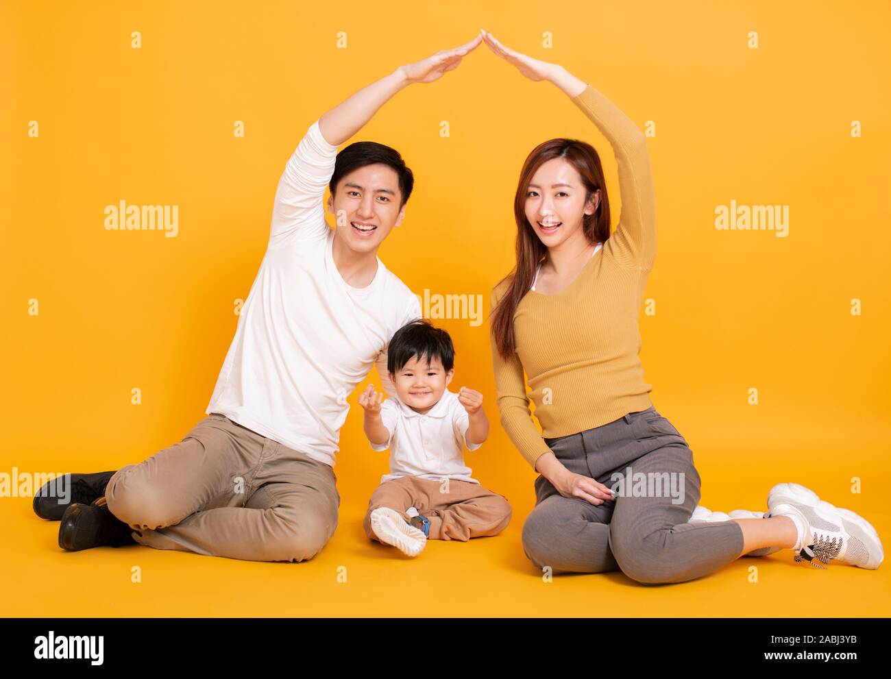 happy young family sitting on floor with home concept Stock Photo