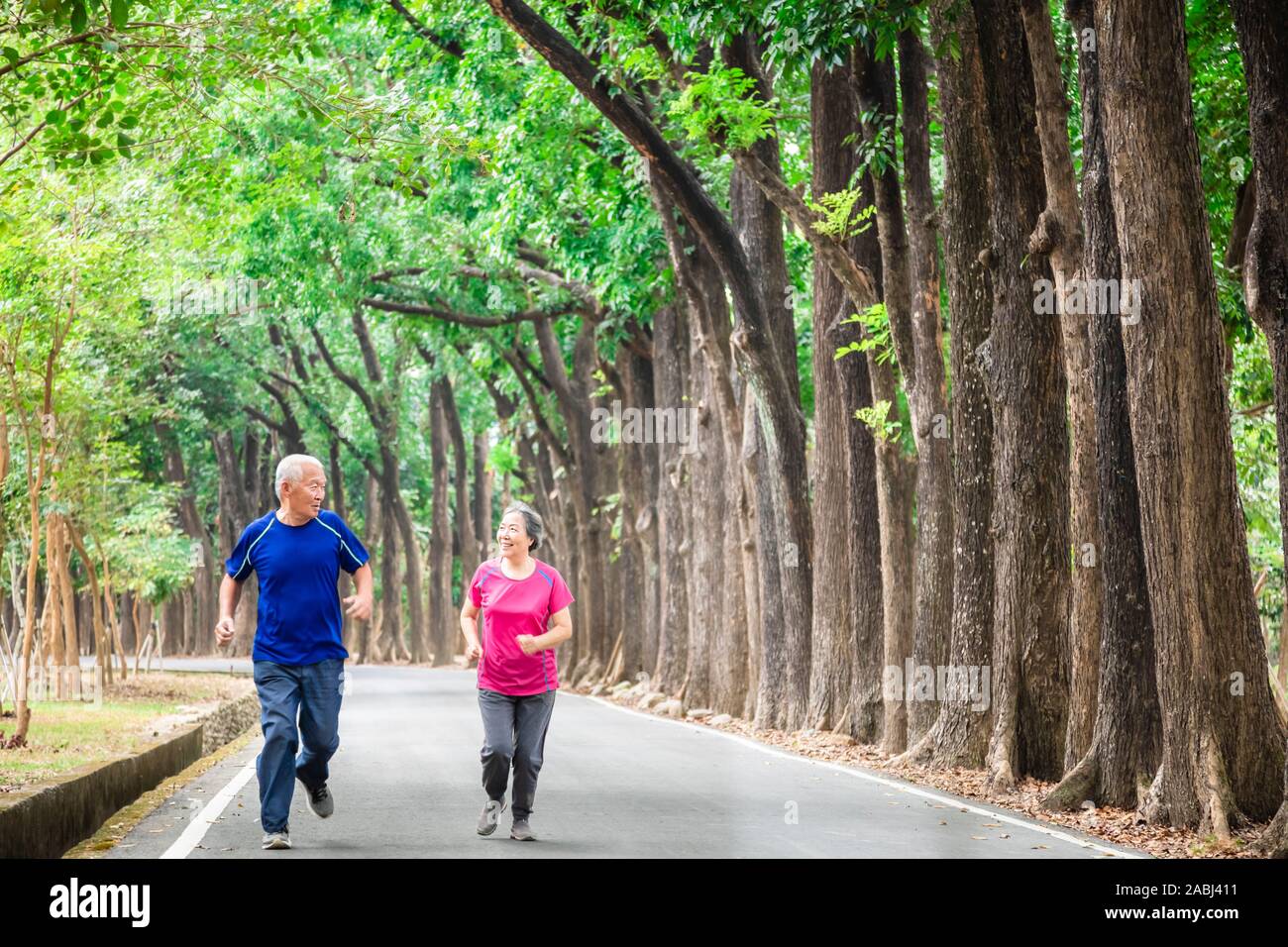 happy asian Senior couple running outside at park Stock Photo - Alamy