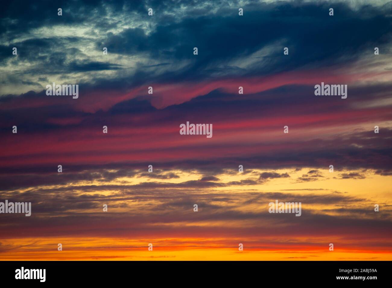 Multicolored dramatic Stratocumulus clouds at sunset. Stock Photo