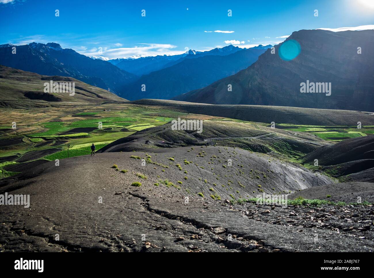 Beautiful mountains in daylight with a man standing below Stock Photo