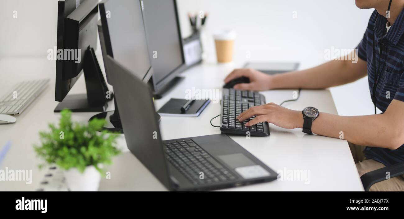 Young professional UI web developer working on his project with laptop ...