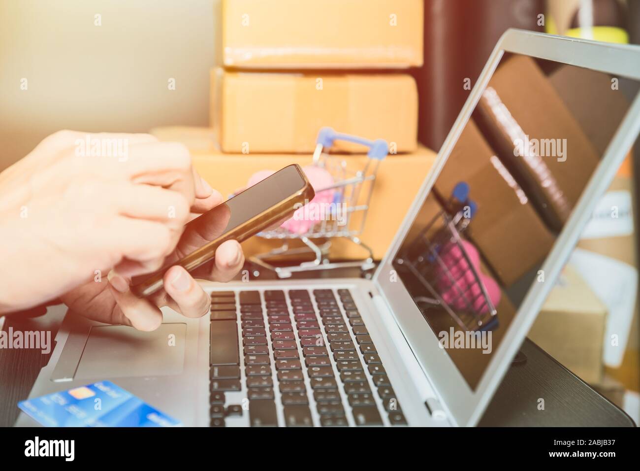 hand checking order at smartphone for online shopping technology from laptop to smart apps. Stock Photo
