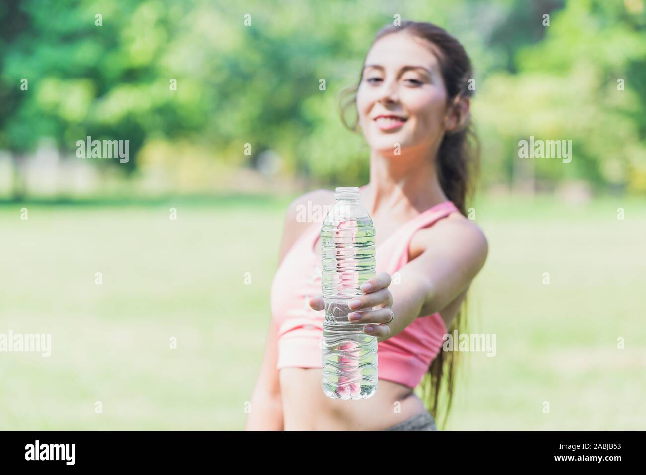 sport women hand show drinking water bottle for recommend to drink clean water for good healthy life. Stock Photo