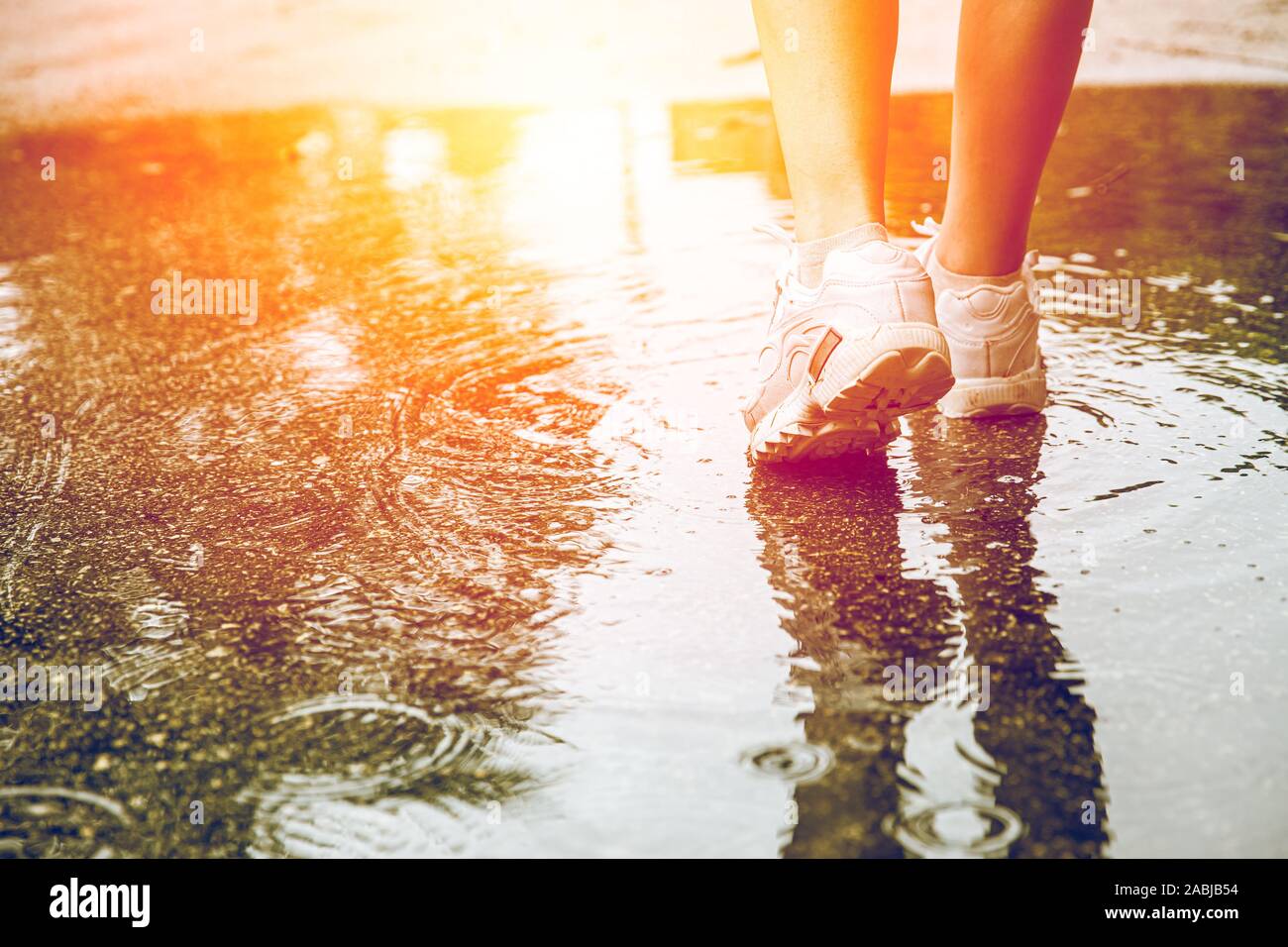 Closeup feet walking in water at the ground after rain for step over obstacles in life to next good thing strong with no fear. Stock Photo