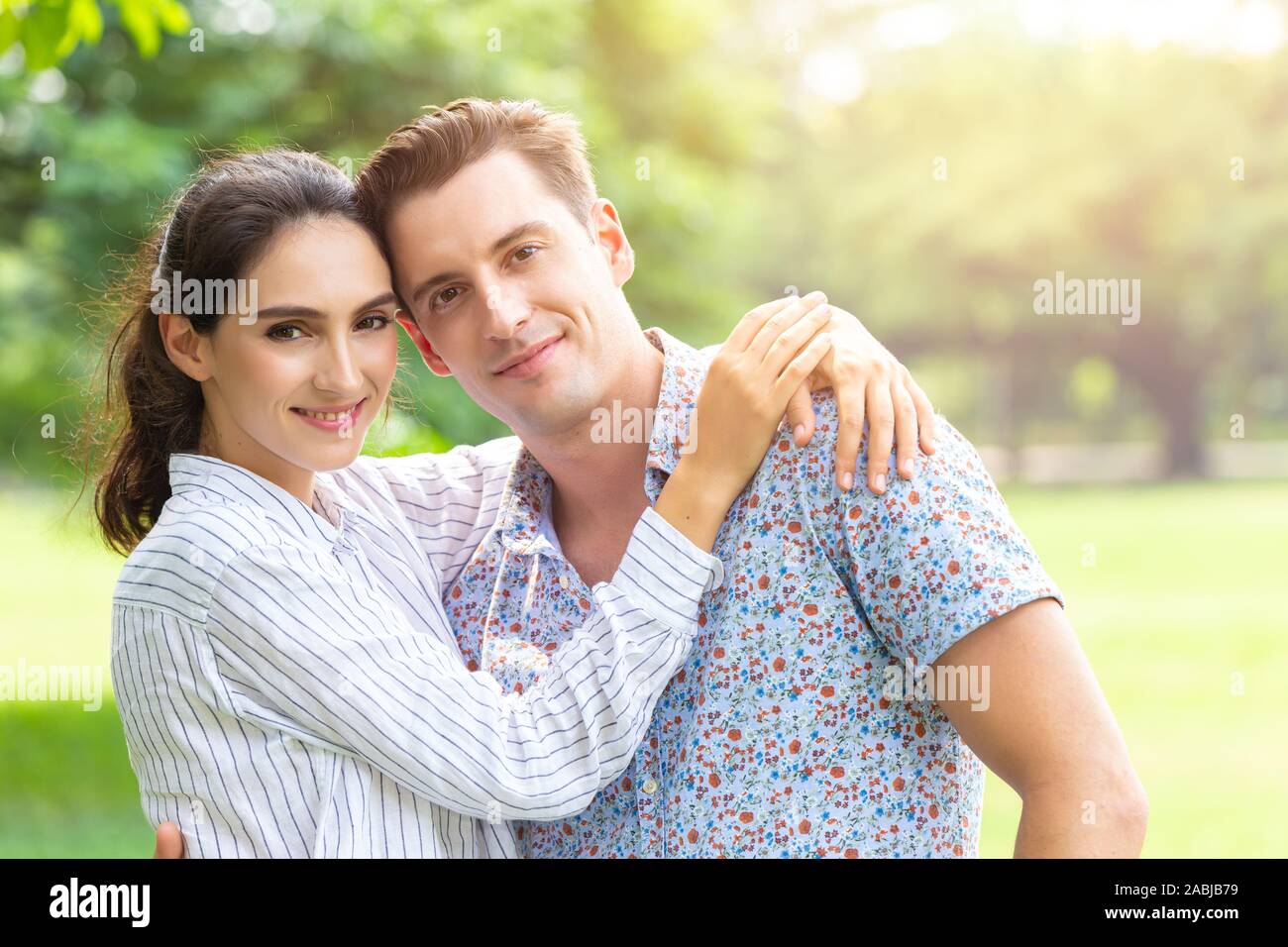 Portrait of Couple lover smiling looking camera outdoor park background with copy space. Stock Photo