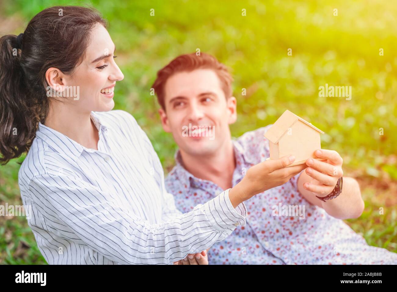 couple lover hand holding home dummy for plan to buying new house for marriage property and living together after married concept. Stock Photo