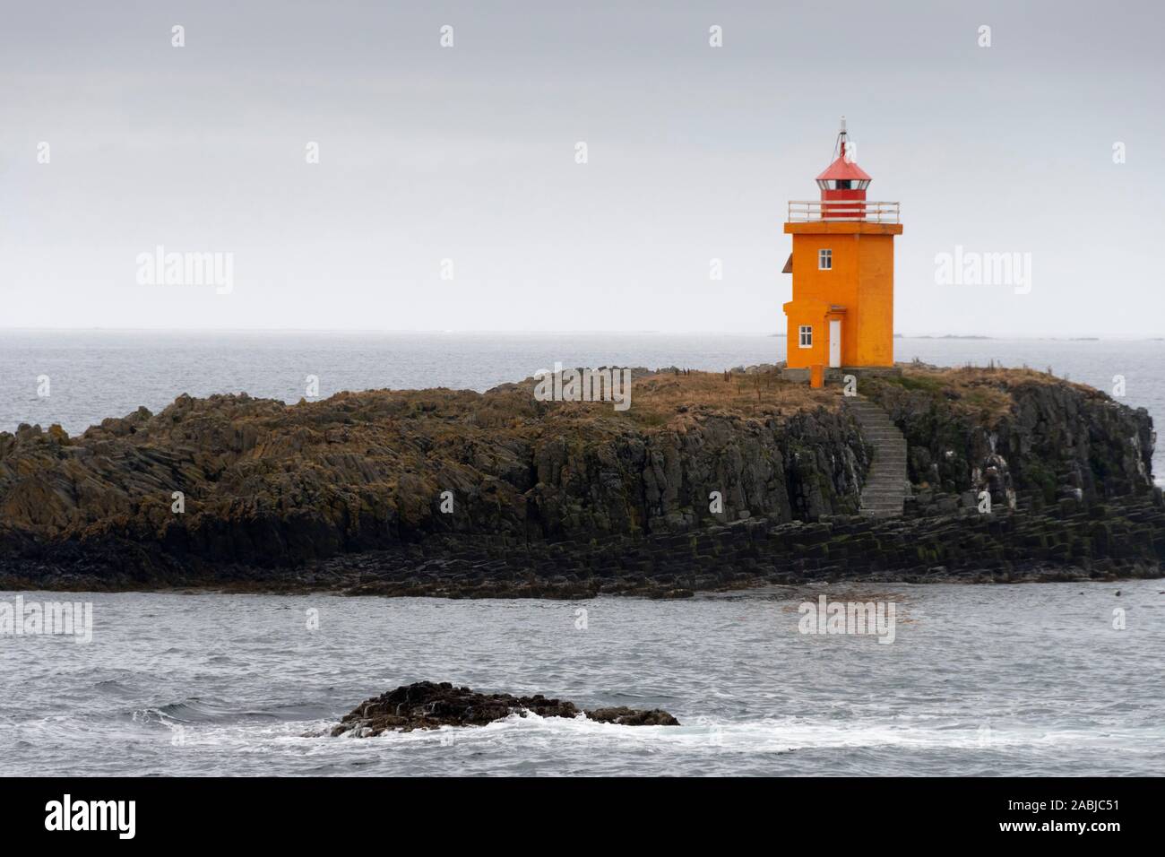 Orange lighthouse on small island near Flatey Island, Iceland Stock Photo