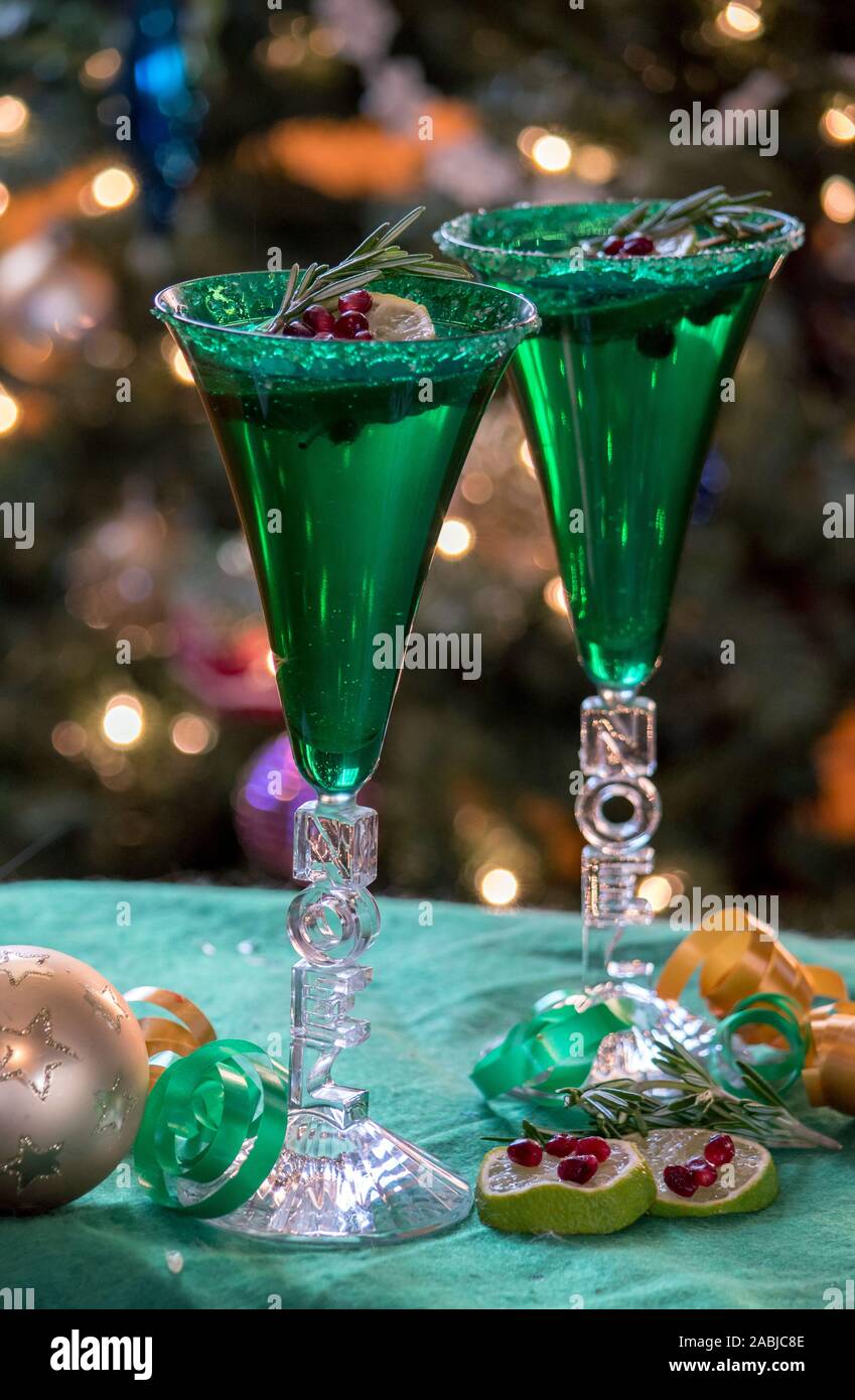 https://c8.alamy.com/comp/2ABJC8E/green-christmas-glasses-hold-champagne-and-are-garnished-with-fruit-and-rosemary-sprigs-2ABJC8E.jpg