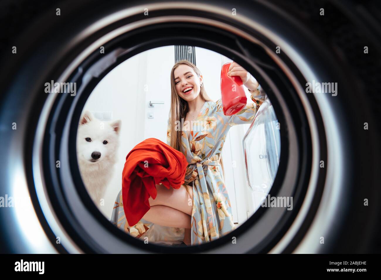 Young woman at home puts the dress in the drying machine. Stock Photo