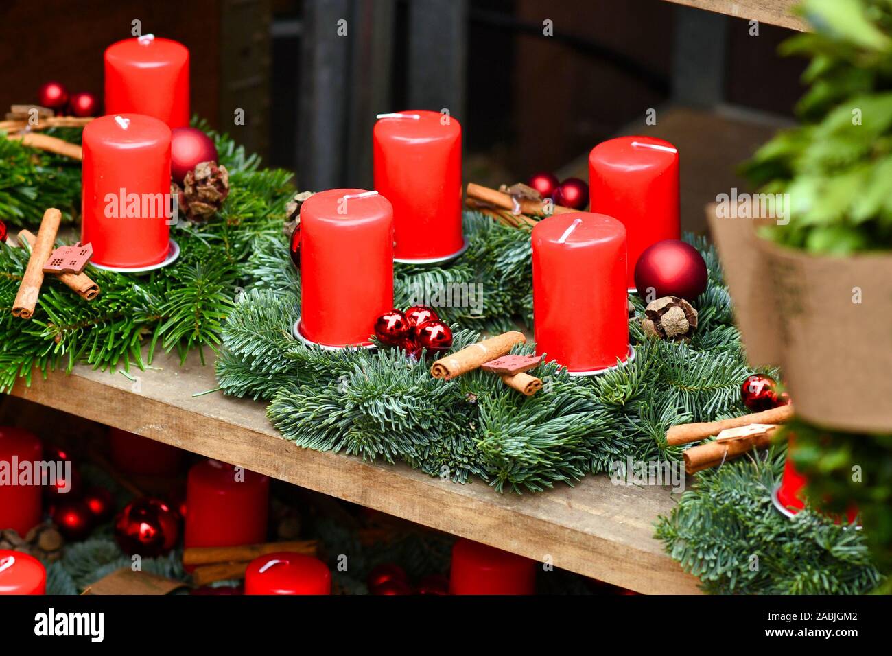 Traditional advent wreaths with four red candles and seasonal Christmas  decorations for sale on wooden shelf Stock Photo - Alamy