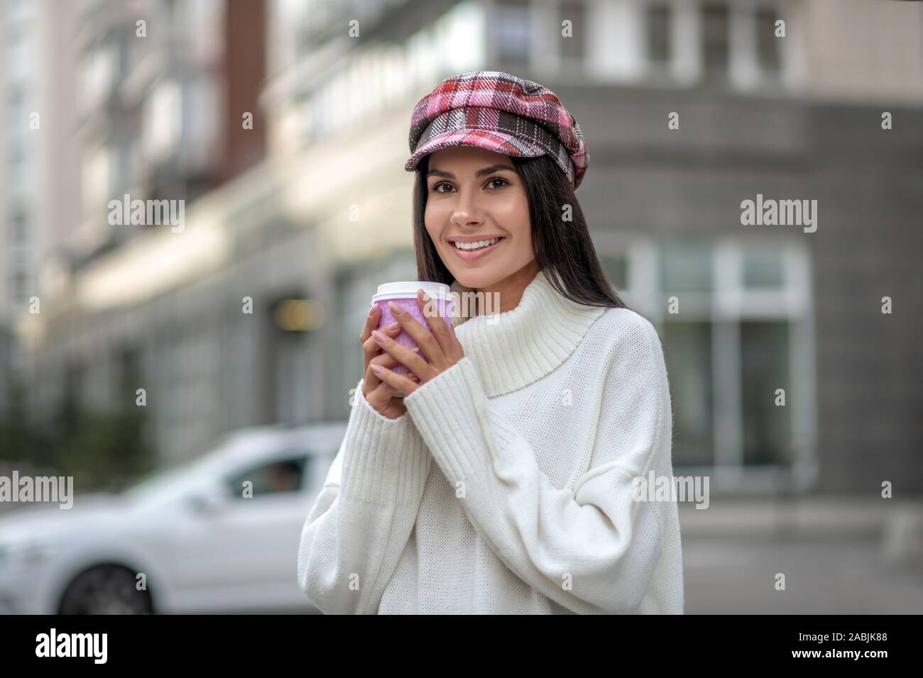 Positive joyful woman holding a cup with coffee Stock Photo