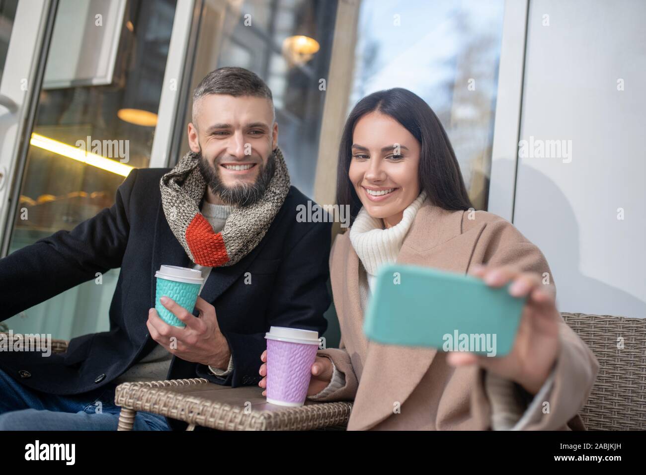 Positive delighted woman holding her new smartphone Stock Photo