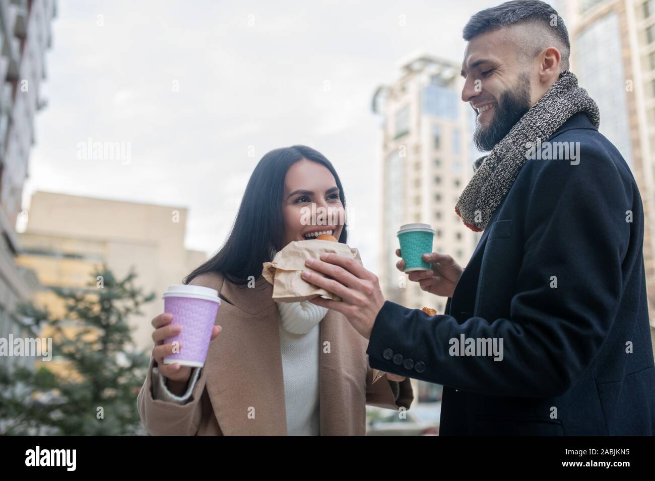 Joyful happy man feeding his beloved wife Stock Photo