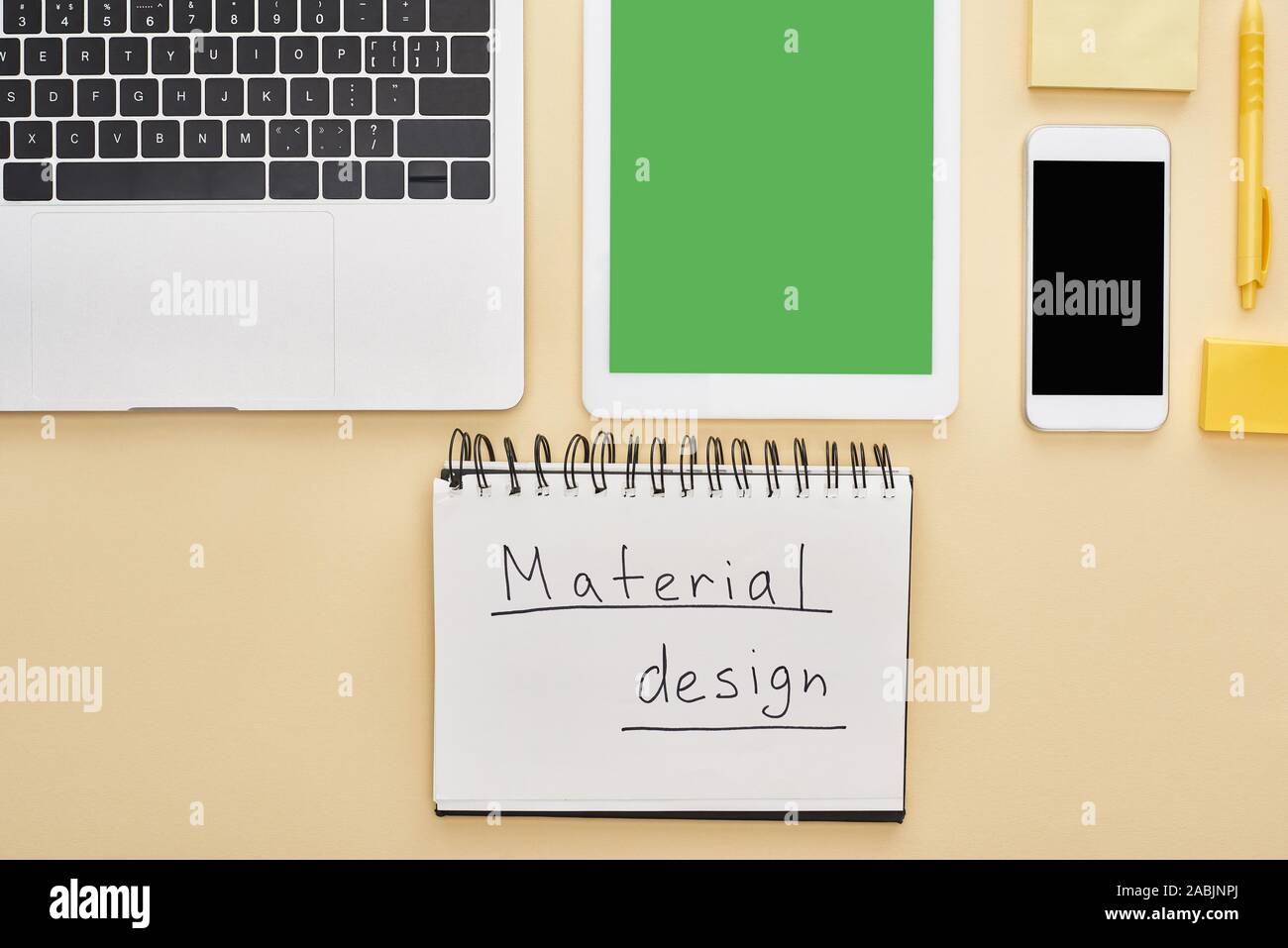 flat lay with gadgets and material design lettering in notepad on ...