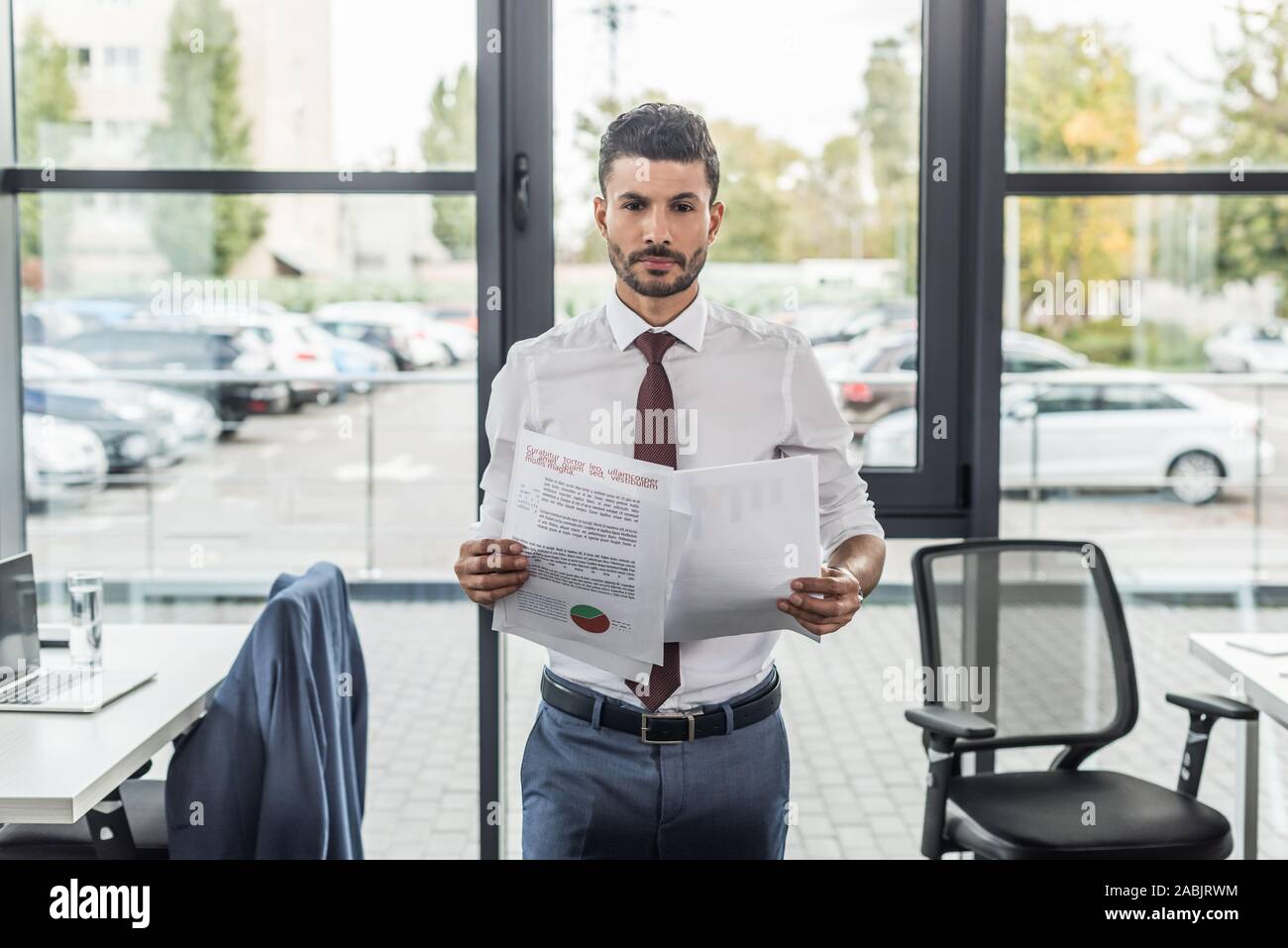 discouraged businessman looking at camera while holding documents Stock Photo