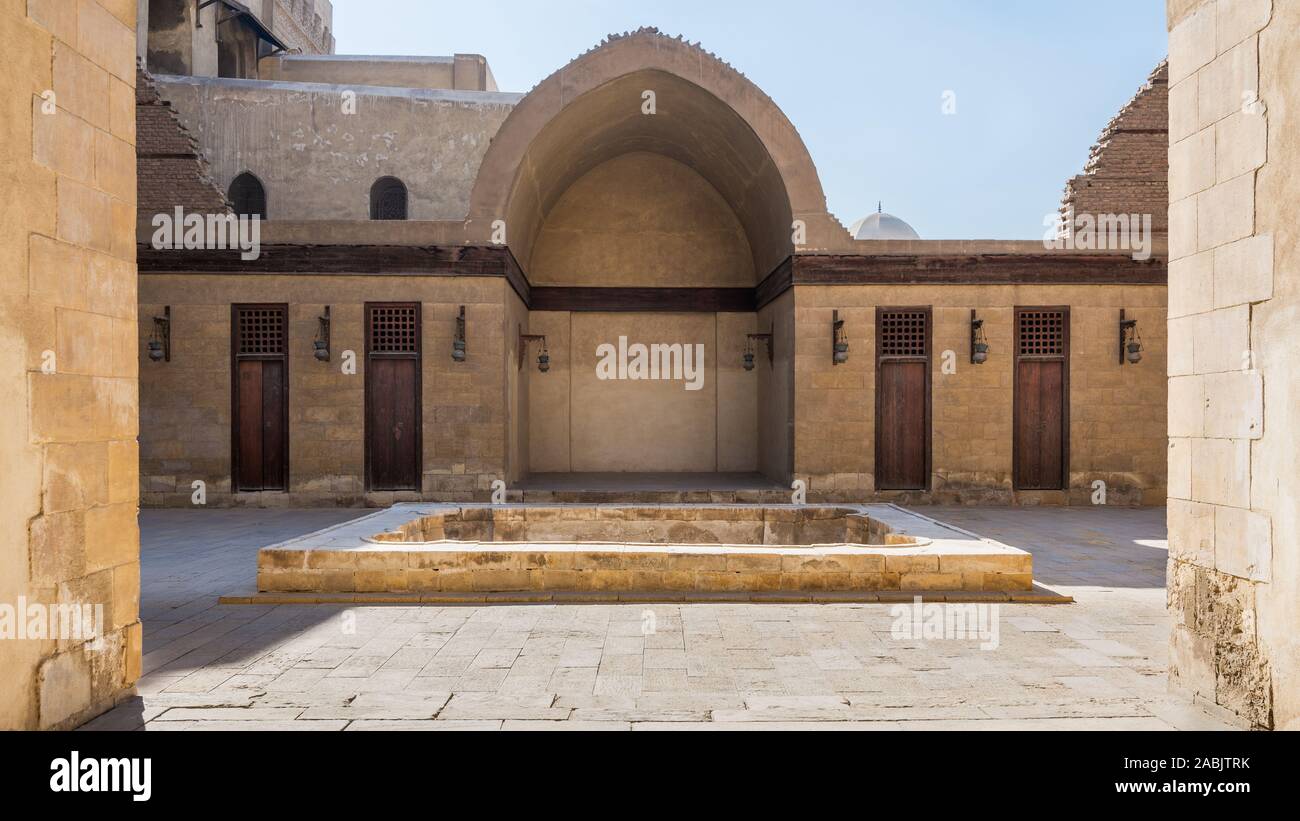 Courtyard of public historic mosque of Sultan Al Nassir Qalawun with side arched iwan and closed wooden doors, Cairo, Egypt Stock Photo