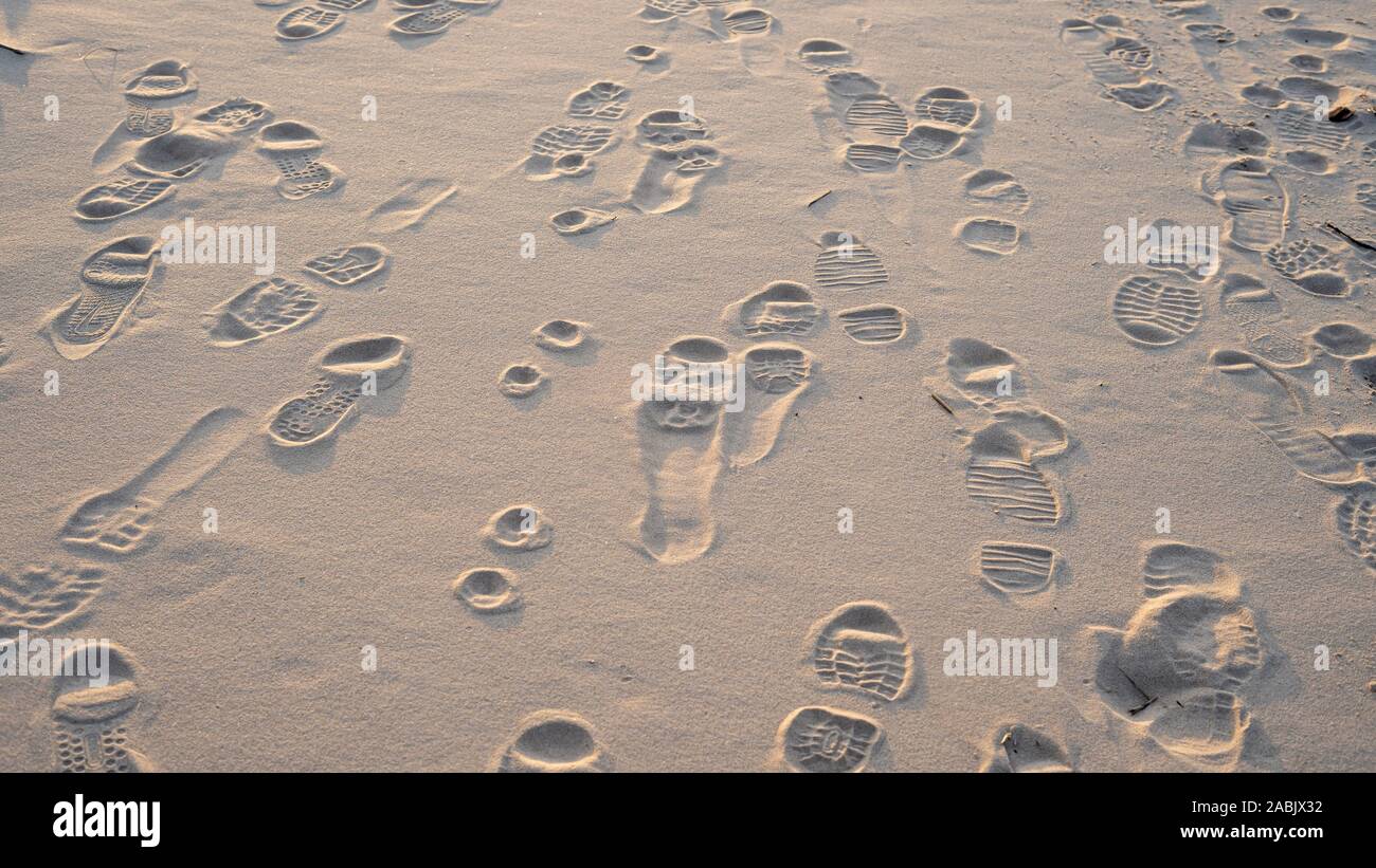 Prints From Various Footwear on Sand. Urban Background. Texture of Yellow Sand With Traces of Different Shoes. Stock Photo