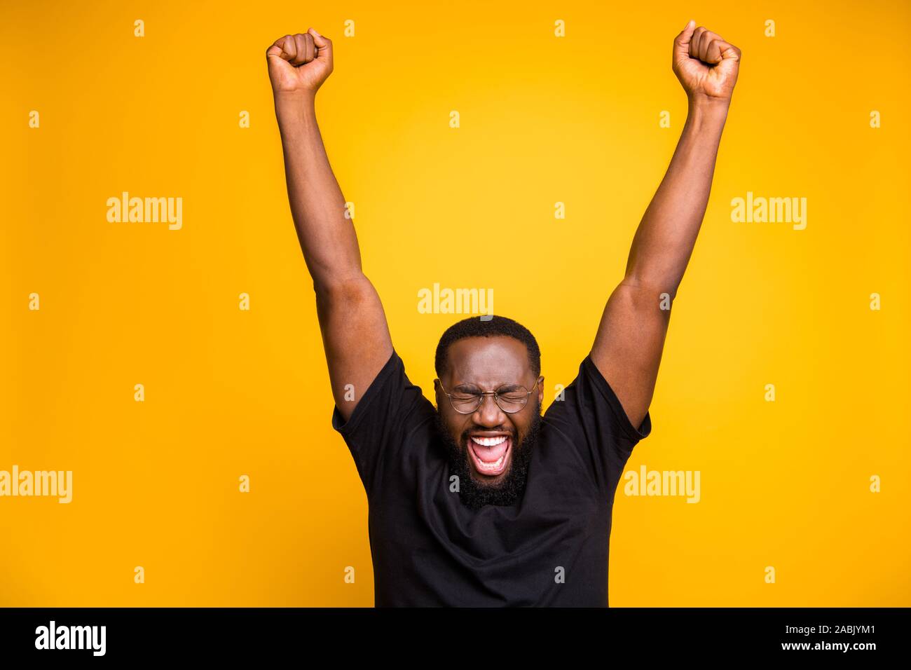 Photo of cheerful positive crazy excited man in spectacles black t-shirt  screaming shouting with rude face expression dreaming raising hands up  Stock Photo - Alamy