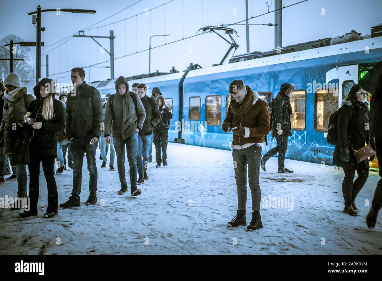 During late afternoon, a Keolis train from Zwolle has arrived in snow coverd Kampen, Netherlands. Stock Photo