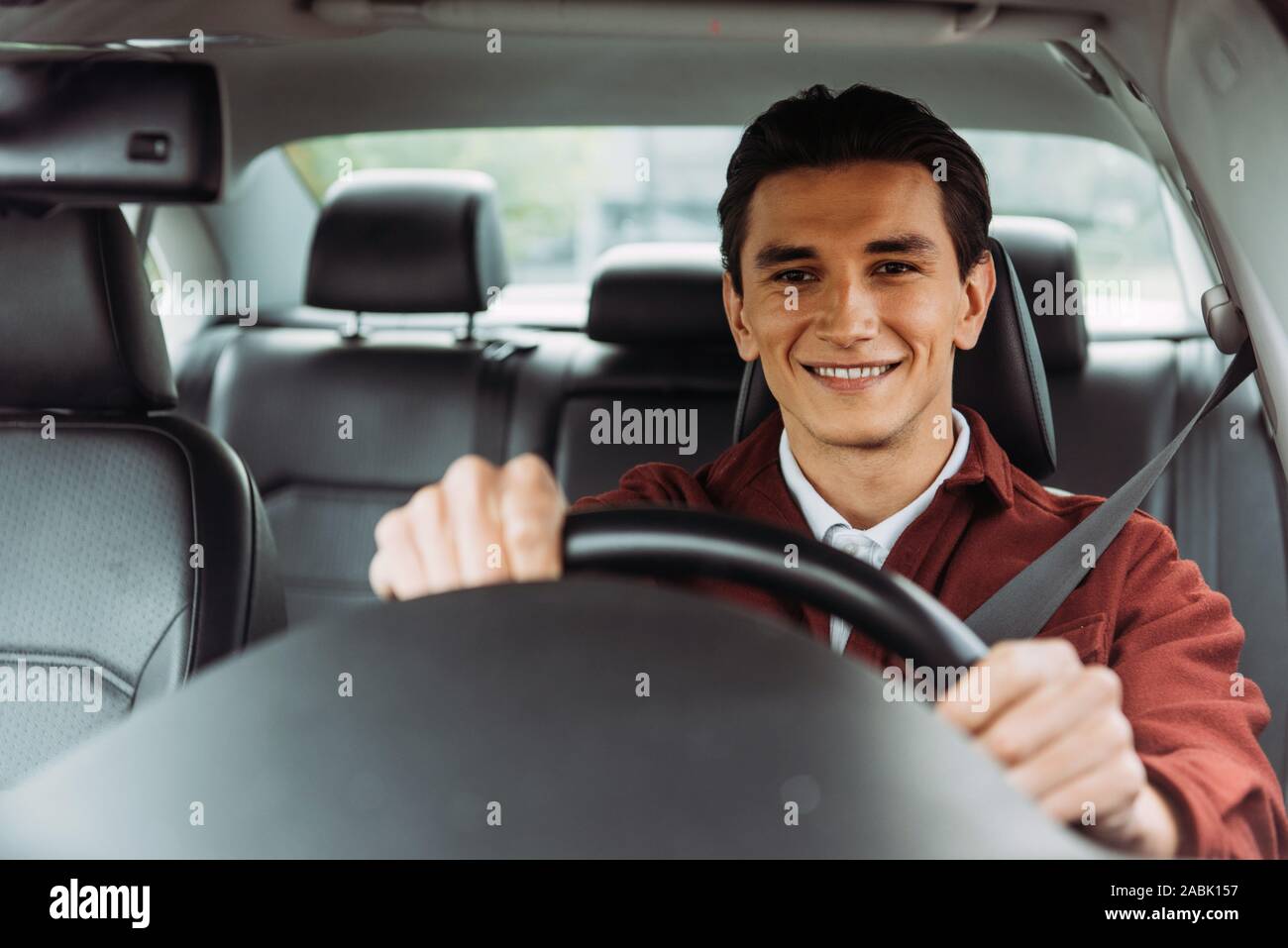 Smiling handsome man holding steering wheel of car Stock Photo - Alamy