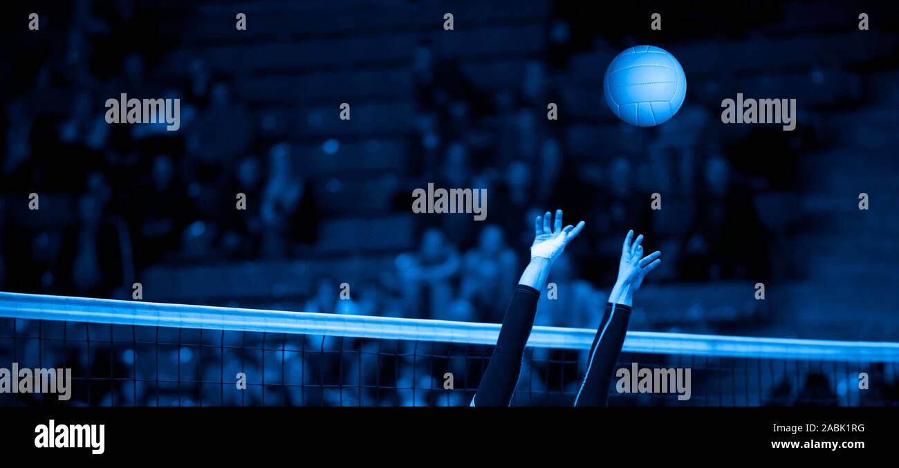 Girl Volleyball player and setter setting the ball for a spiker during