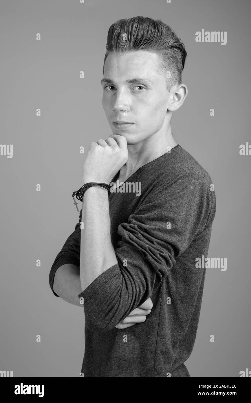 Portrait of young man against gray background in black and white Stock ...