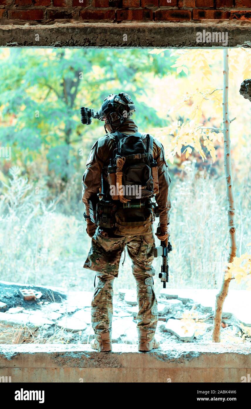 Airsoft man in uniform with machine gun and nightvision device on