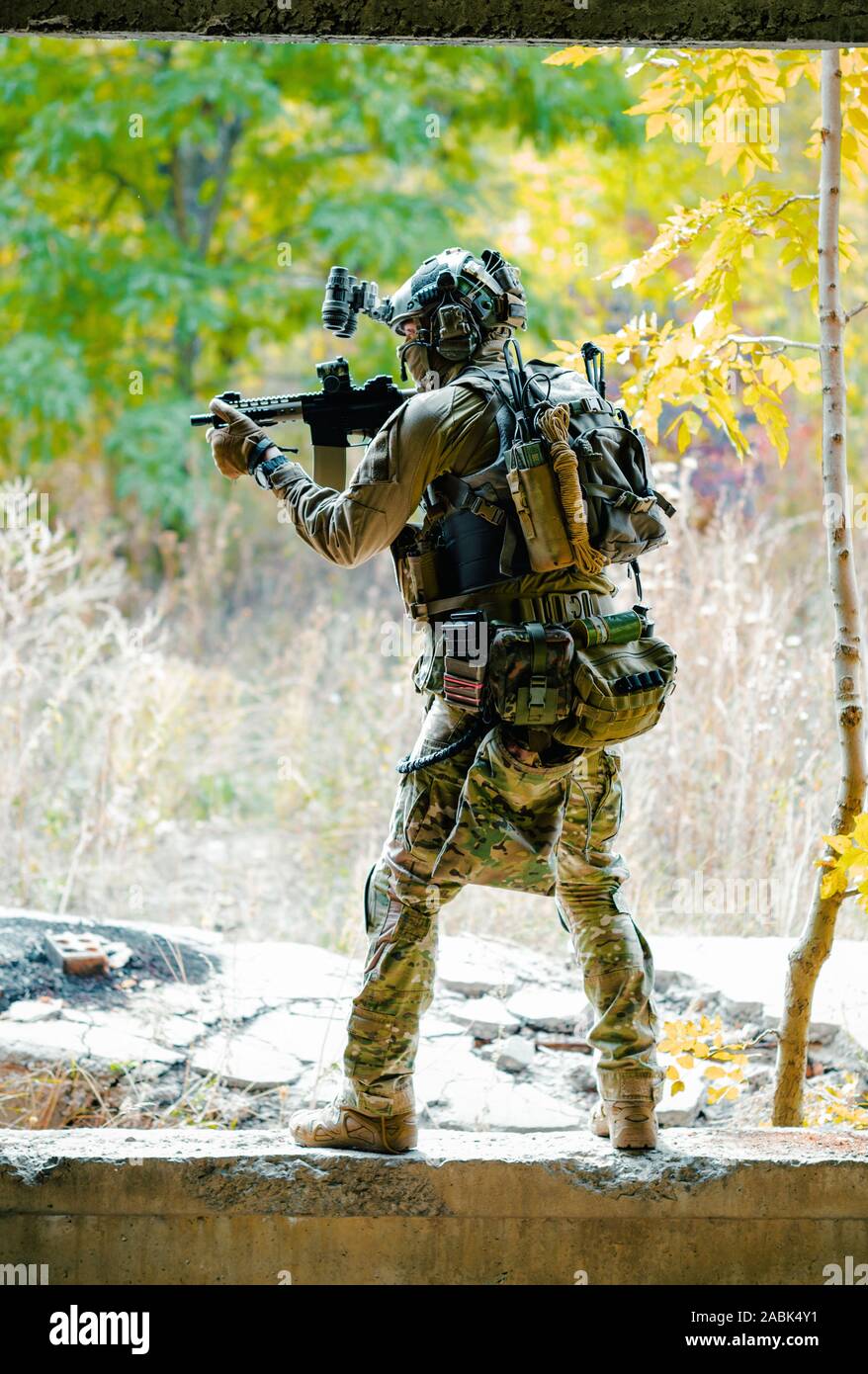 Airsoft man in uniform with machine gun and nightvision device on
