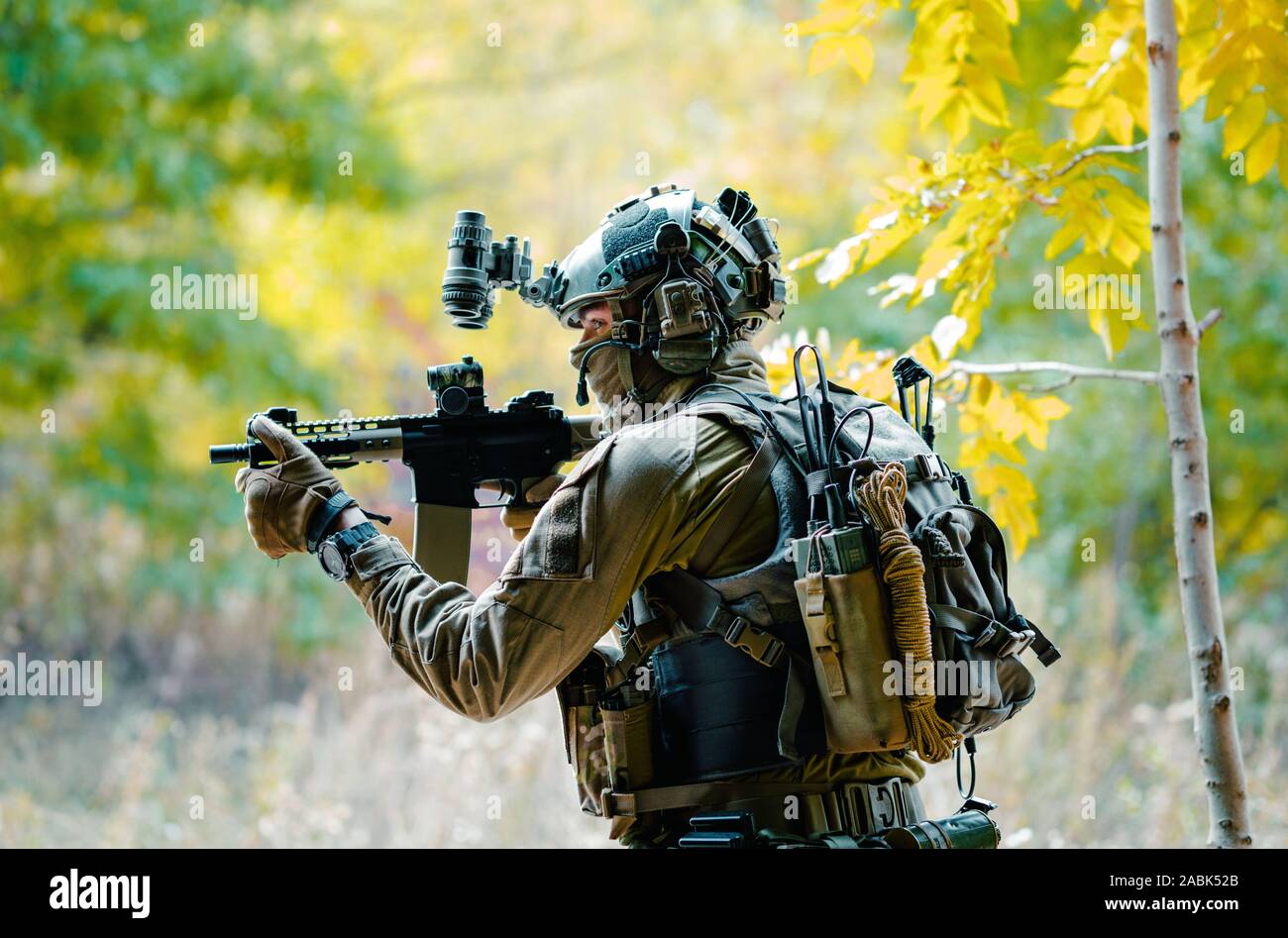 Airsoft man in uniform with machine gun and nightvision device on