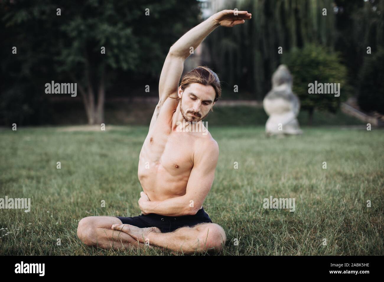 Yoga at park. Bearded man doing yoga in the green park. Concept of a ...