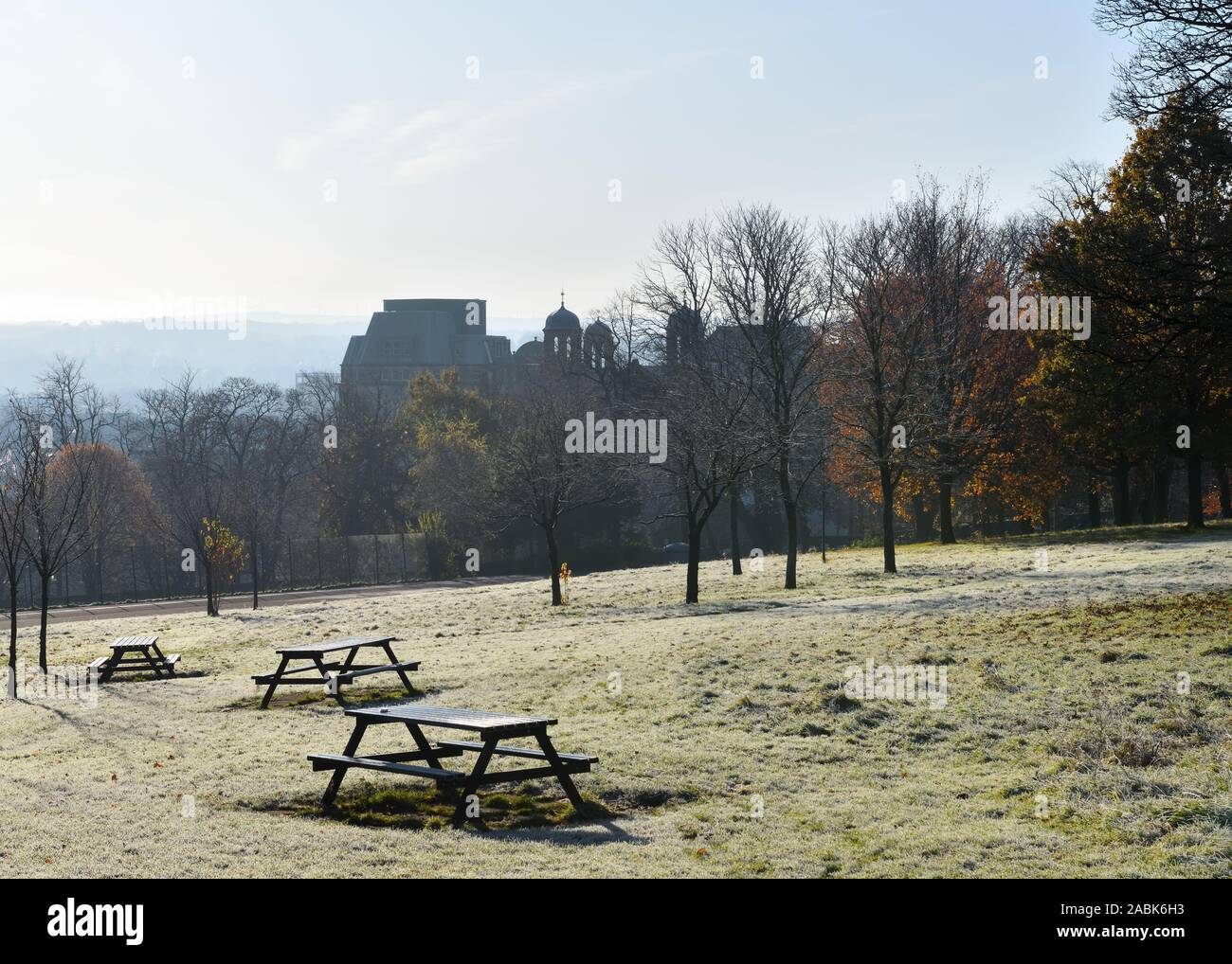 Frost on the ground, at the end of Autumn in Queen's Park, Glasgow, overlooking the silhouetted towers of the old Victoria hospital in Scotland, Uk Stock Photo