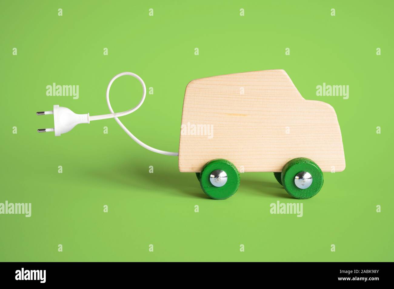 Electric ecofriendly car concept. Wooden toy car with electric plug