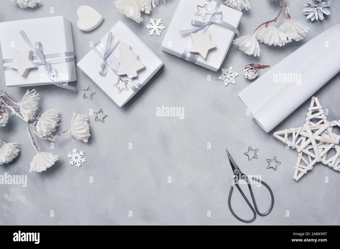 Border Design a Christmas greeting card with Xmas gift boxes, scissors, cones, star, snowflakes with place for your text. Decoration on a white wooden Stock Photo