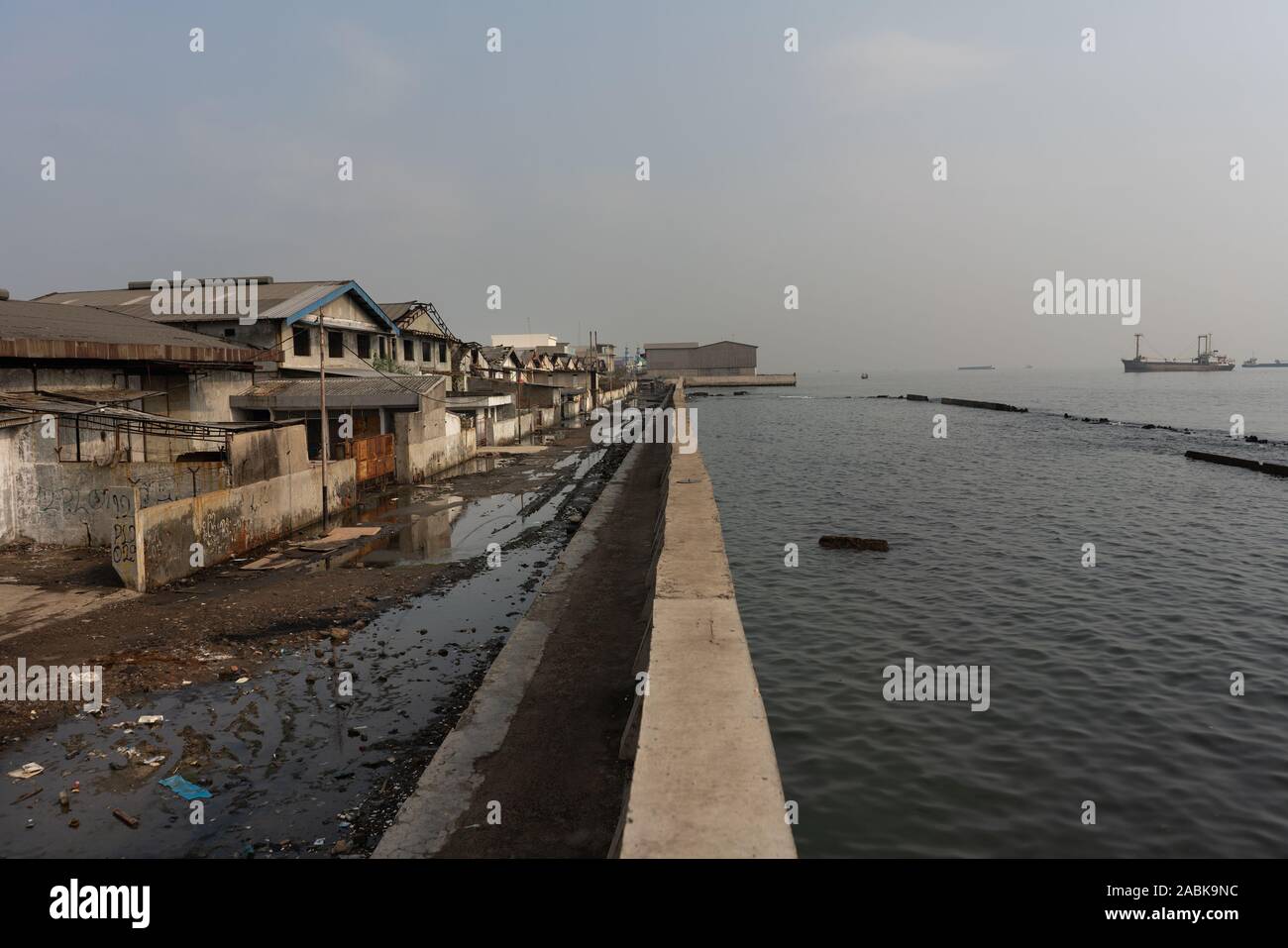 Jakarta, Indonesia. 18th Oct, 2019. Empty buildings stand along a bank in Muara Baru, North Jakarta, Indonesia. The area is below sea level and is frequently affected by flooding. (to dpa: "The sea, the wall and power of destroyed nature") Credit: Fauzan Ijazah/dpa/Alamy Live News Stock Photo