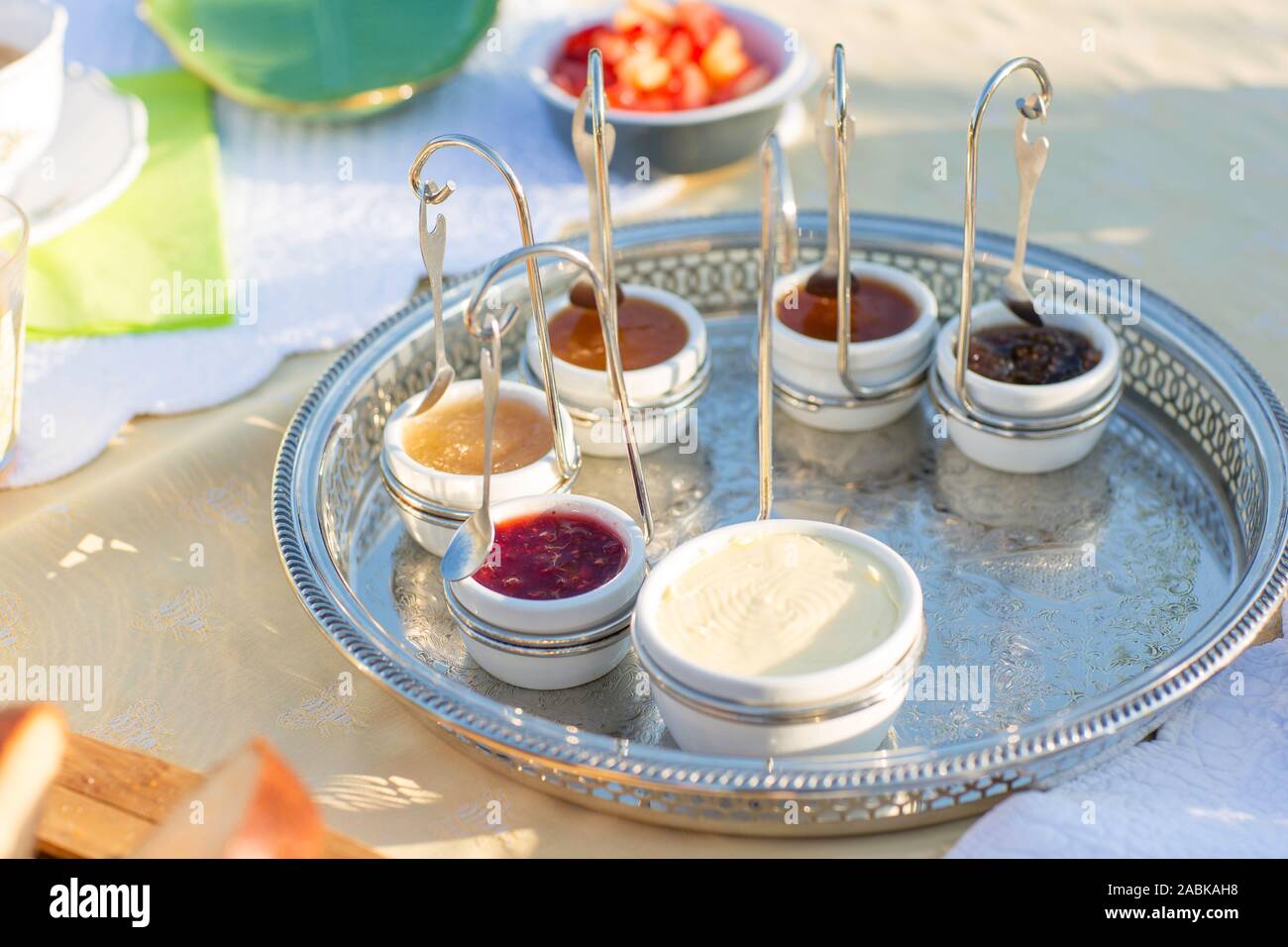 Homemade french brioche breakfast on a cutting board with homemade jam and butter in cups. Sunny day in summer. Relaxing, good feeling. Tasting differ Stock Photo