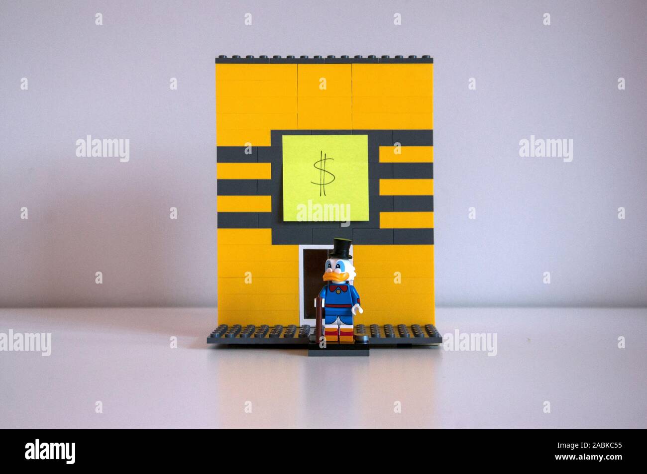 An improvised lego structure of Uncle Scrooge's money bin. Uncle Scrooge figurine standing in front of the bin. Stock Photo