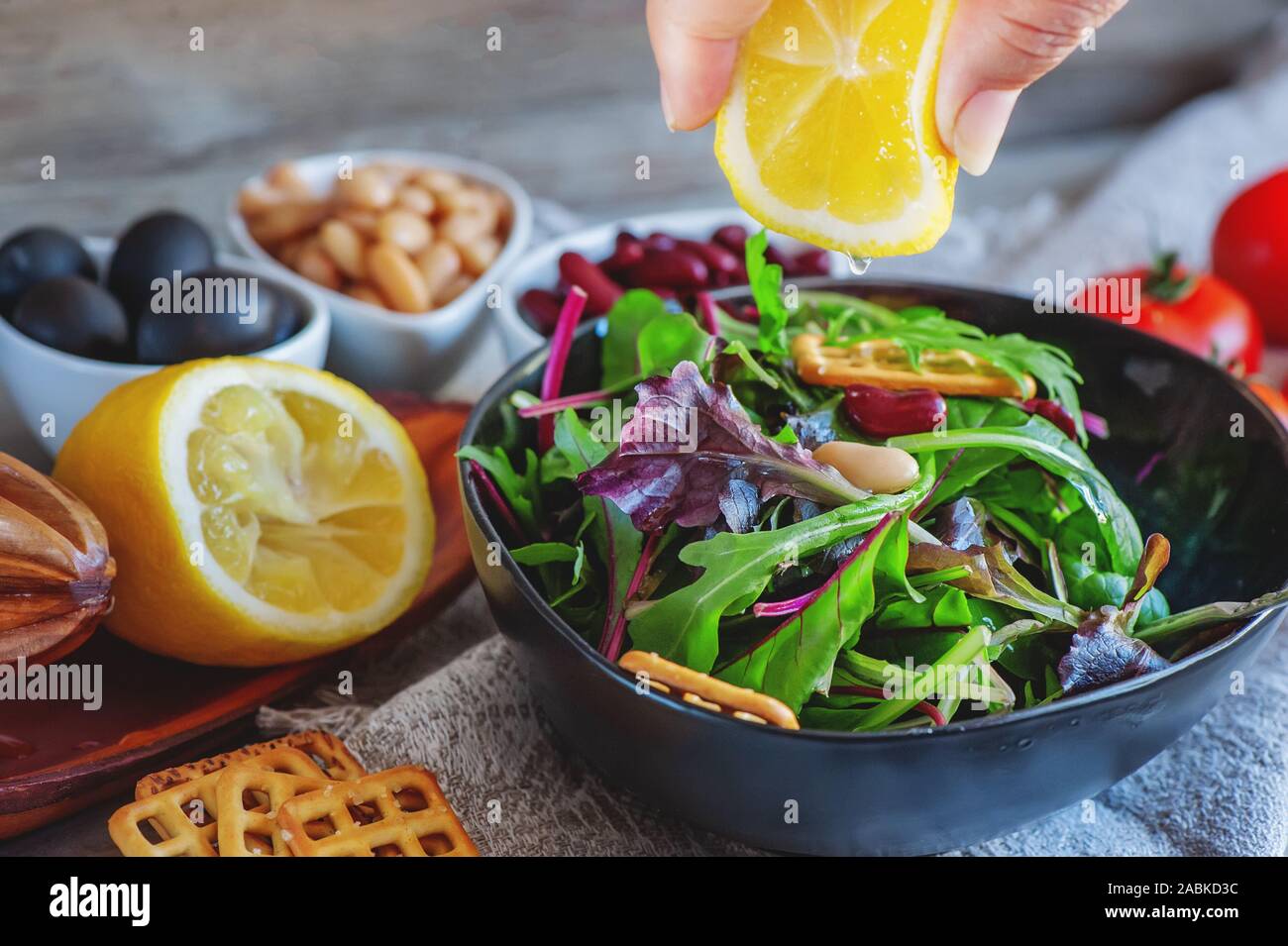 Delicious and healthy salad with beans, arugula, tomatoes and lemon juice. Healthy fitness food for dieters and vegans. Stock Photo