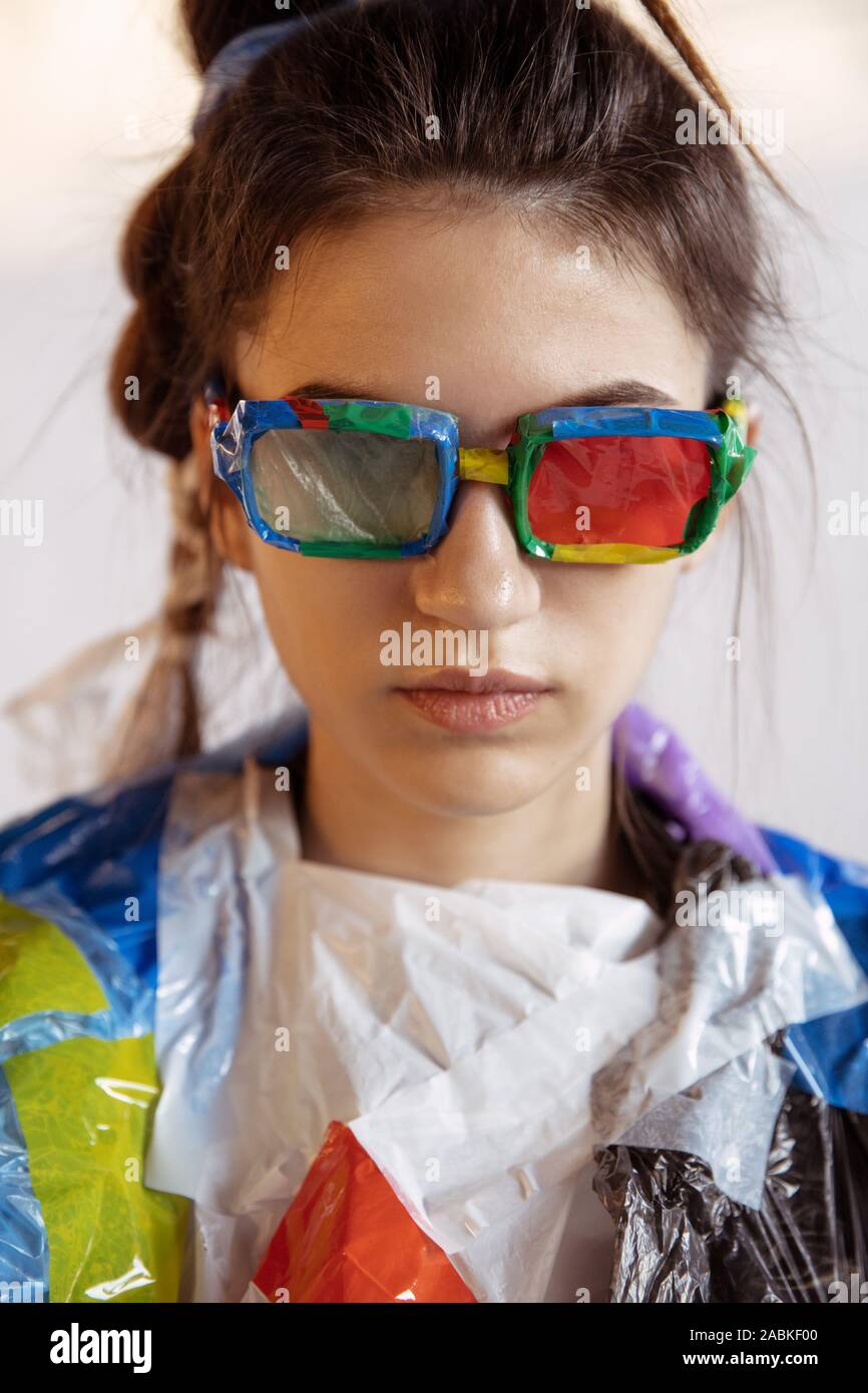 Woman wearing plastic on white background. Female model in clothes and