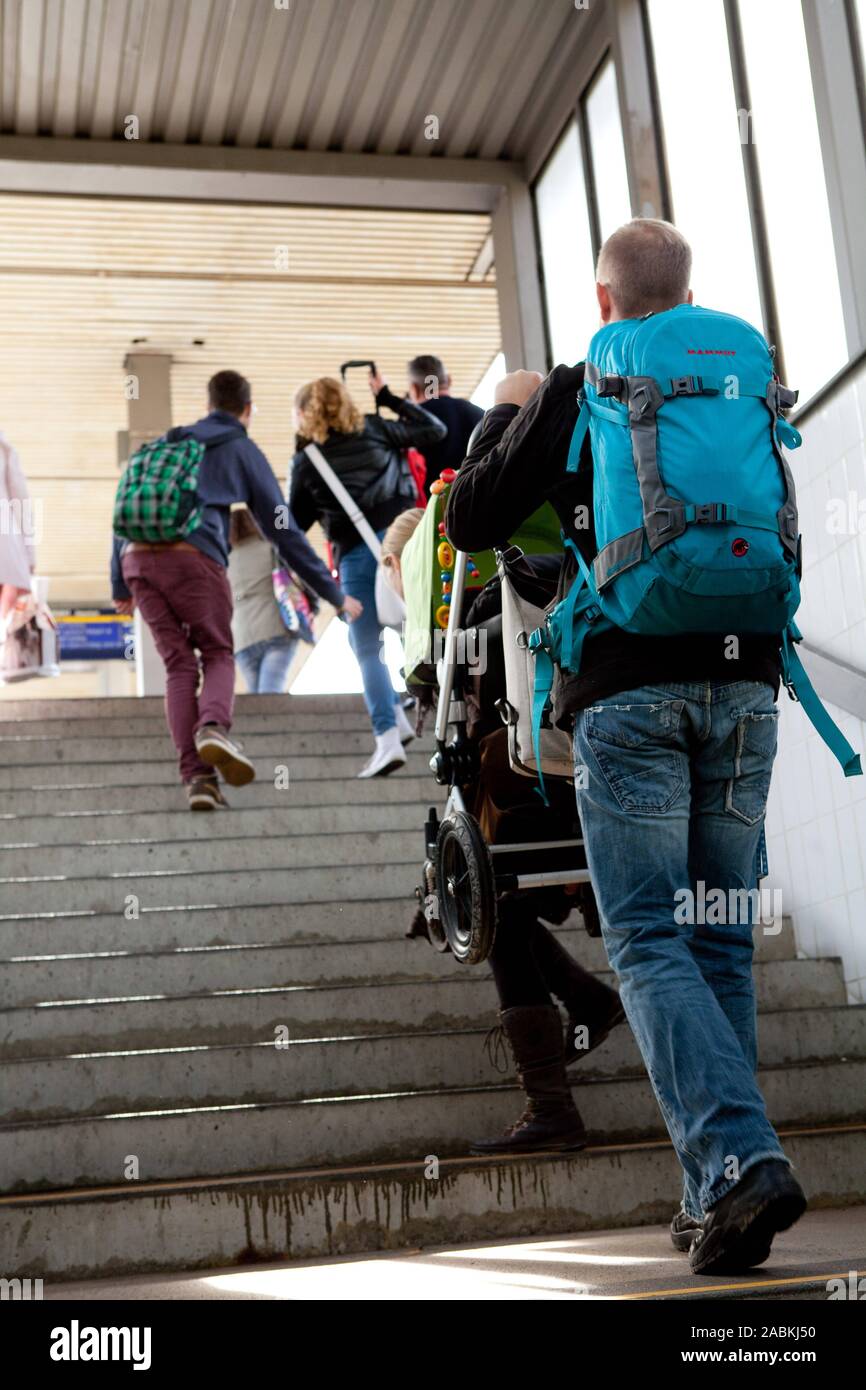 The staircase at Johanneskirchen S-Bahn station represents an insurmountable hurdle for elderly people, the disabled and parents with prams. In the picture a father carries a pram up the stairs due to the missing lift. [automated translation] Stock Photo
