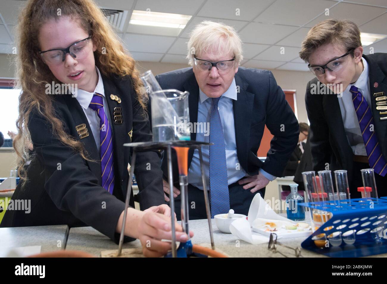 Prime Minister Boris Johnson helps with a science demonstration with Ruby Cutler (left), year 11 head girl, and Matthew Upright, year 11 head boy, during a visit Chulmleigh College in Chulmleigh, Devon, whilst on the General Election campaign trail. Stock Photo