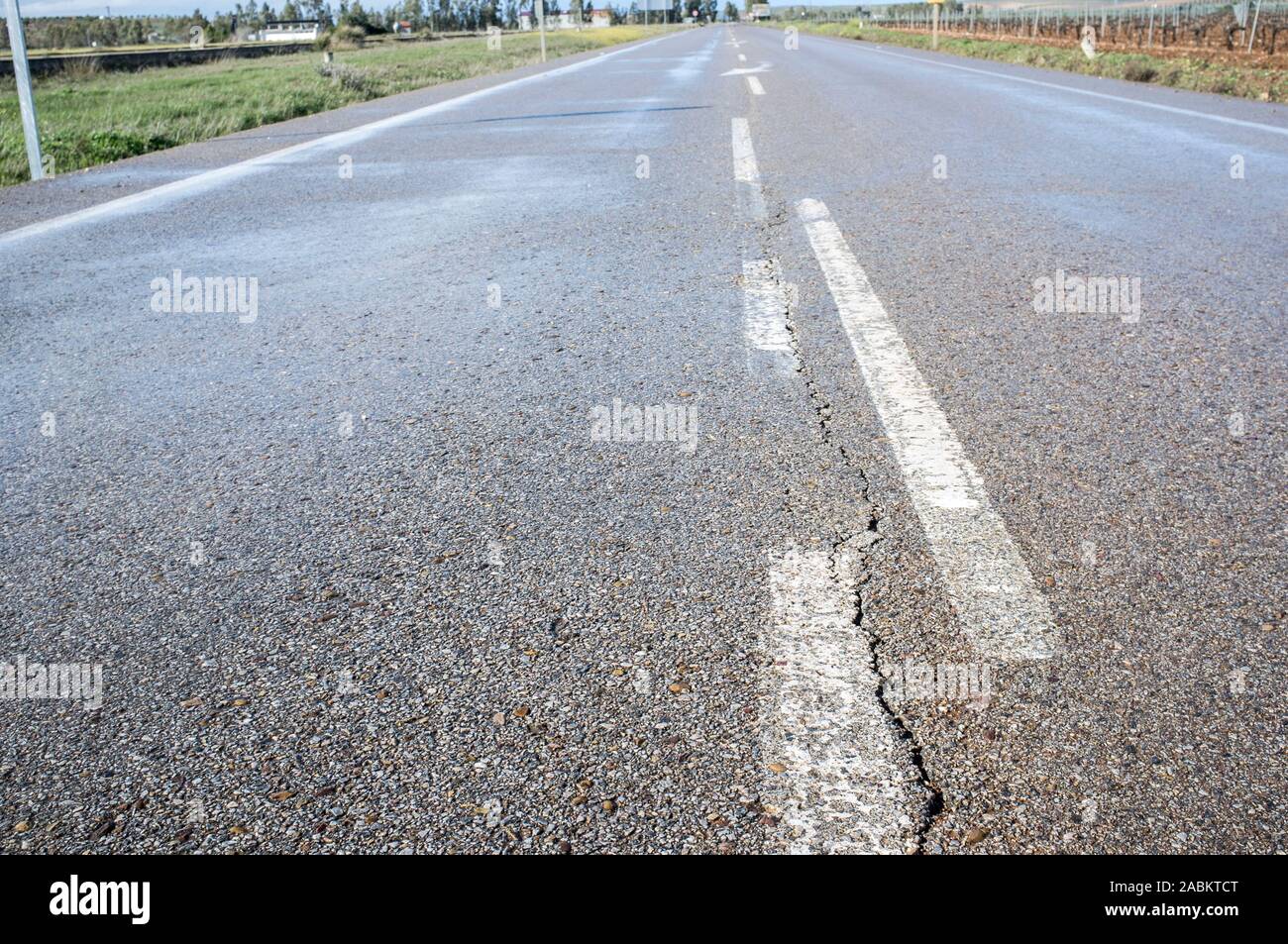 New road with cracked asphalt surface at country way. Deficient  execution of civil construction concept Stock Photo