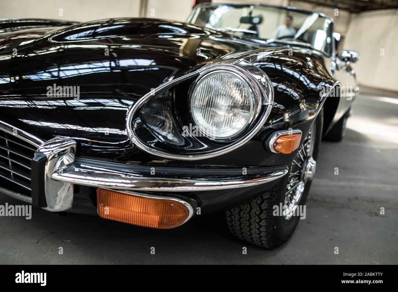 A Black Oldtimer Of The Type Jaguar E Type V12 Is Standing In The