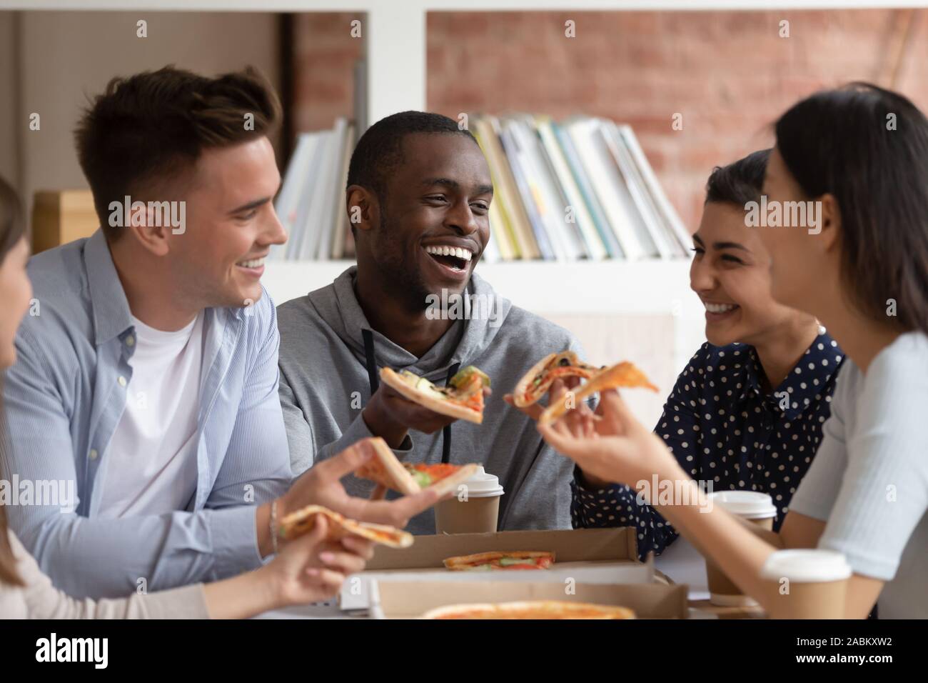 Group of diverse students ordered delivery fast food in campus Stock