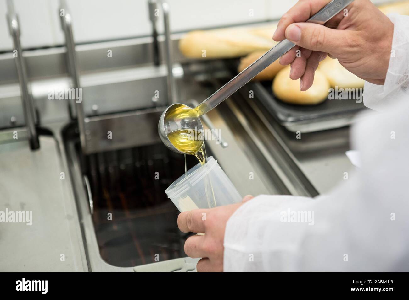 In a staged food inspection, fat is checked in the deep fryer. The ...