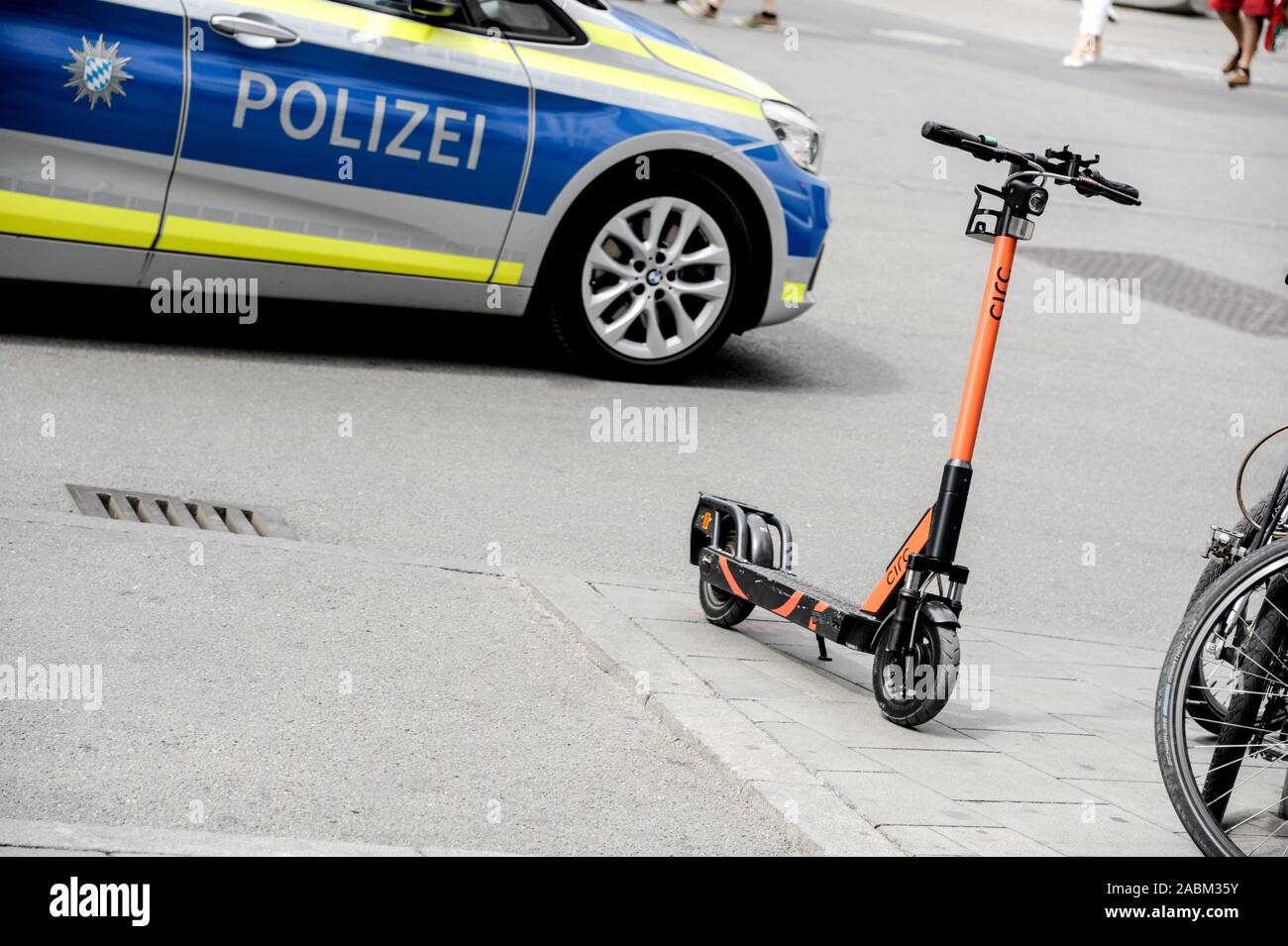 Parked electric scooter of the supplier Circ in Munich. There's a police car in the background. [automated translation] Stock Photo