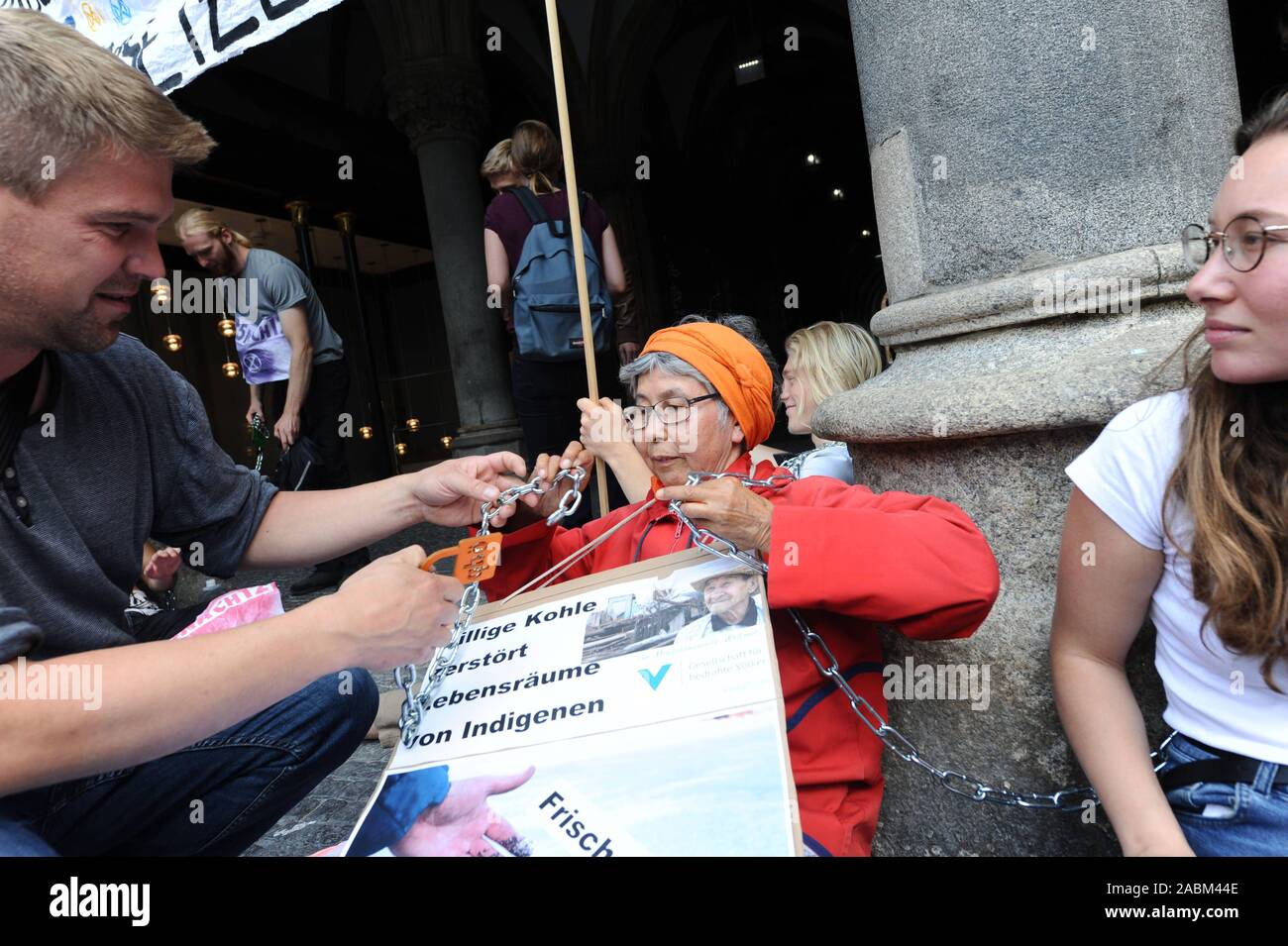 Climate protection activists of the 'Extinction Rebellion' group are protesting against the city's plan to allow the hard coal-fired unit of the Munich-North combined heat and power plant to continue to run after 2022 with a chain protest in front of the Munich City Hall. This would mean that those responsible would ignore the successful citizens' decision to withdraw from the coal industry prematurely. In the picture, ÖDP city councillor Tobias Ruff liberates activist Tjan Zaotschnaja from Siberia, who has hung a sign of the Society for Threatened Peoples around her. [automated translation] Stock Photo