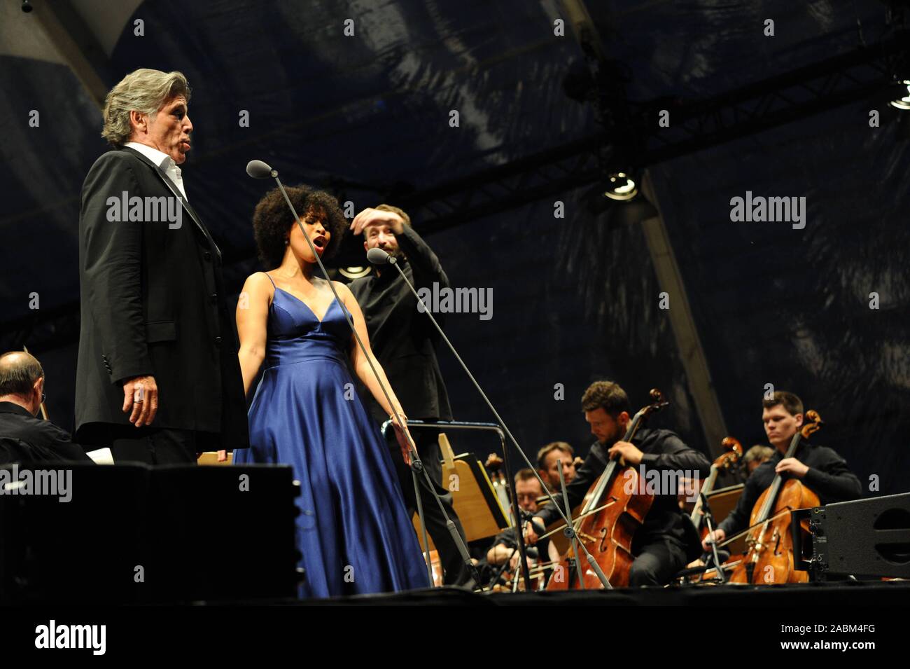'Opera for All' at Munich's Marstallplatz: more than 10,000 visitors listen to the festival concert with the Bavarian State Orchestra conducted by Music Director Kiril Petrenko (r.) and the two soloists Golda Schulz (m.) and Thomas Hampson (l.). Works from various Broadway musicals will be performed. [automated translation] Stock Photo