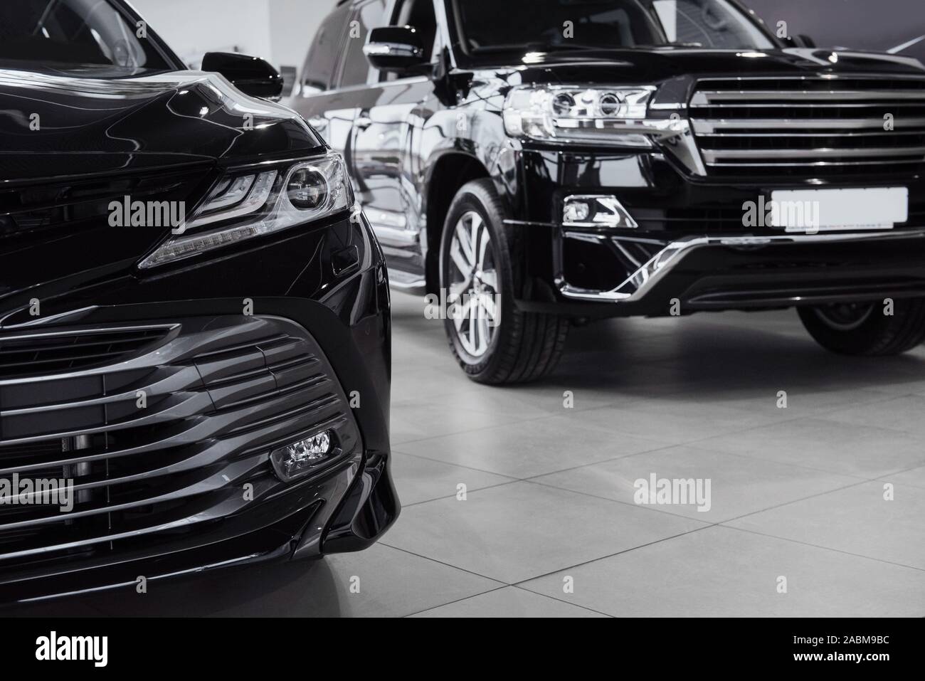 New shining beautiful cars stand near desk reception in car shop Stock