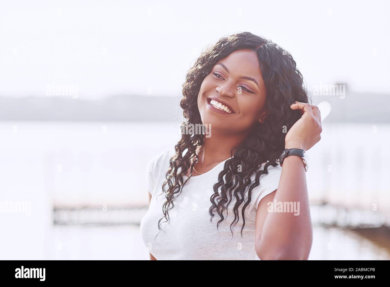 Portrait of smiling young black woman with sunlight flare Stock Photo ...